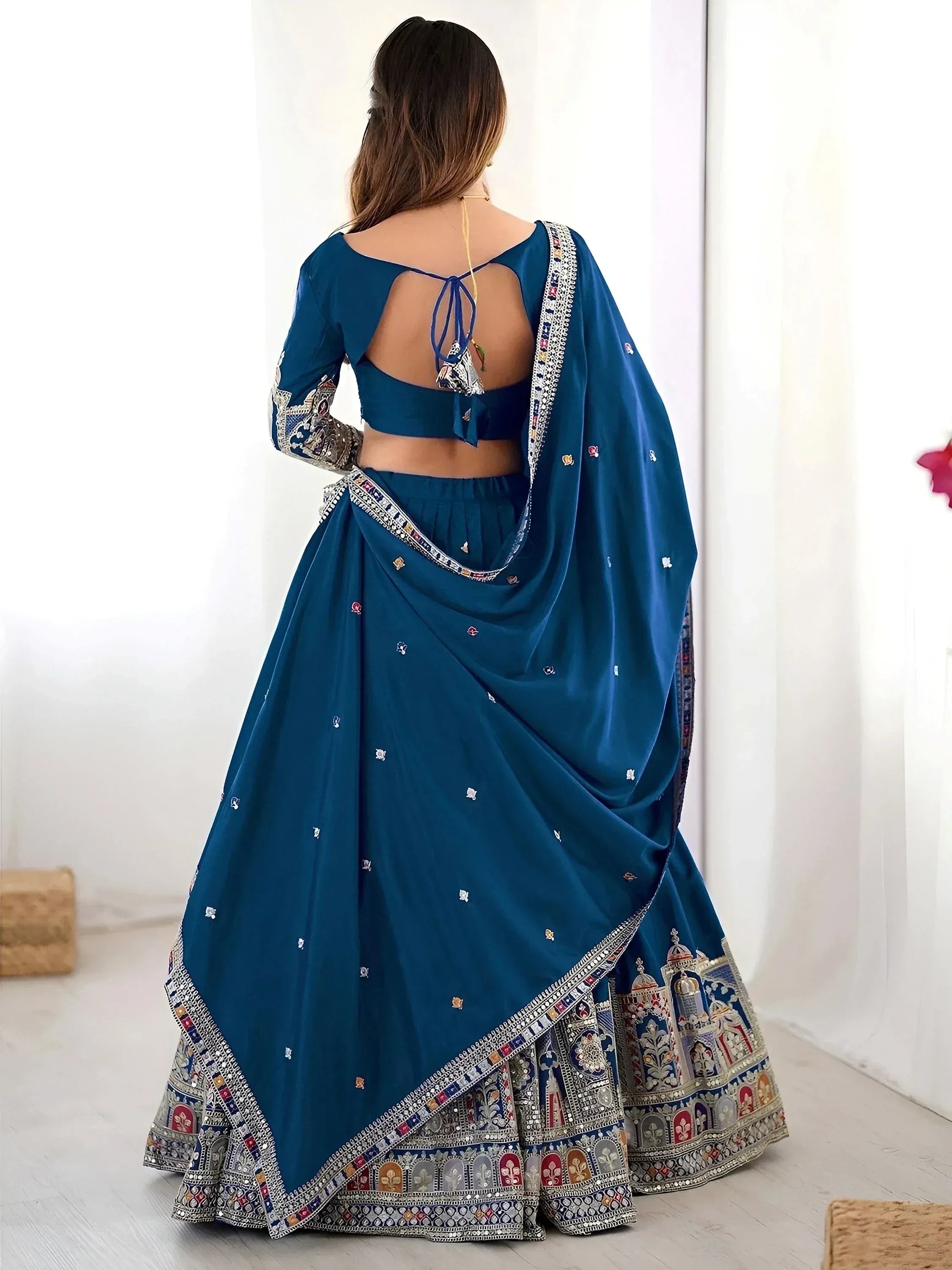 Teal blue designer lehenga choli with intricate embroidery and open back blouse, perfect for Indian ethnic wear