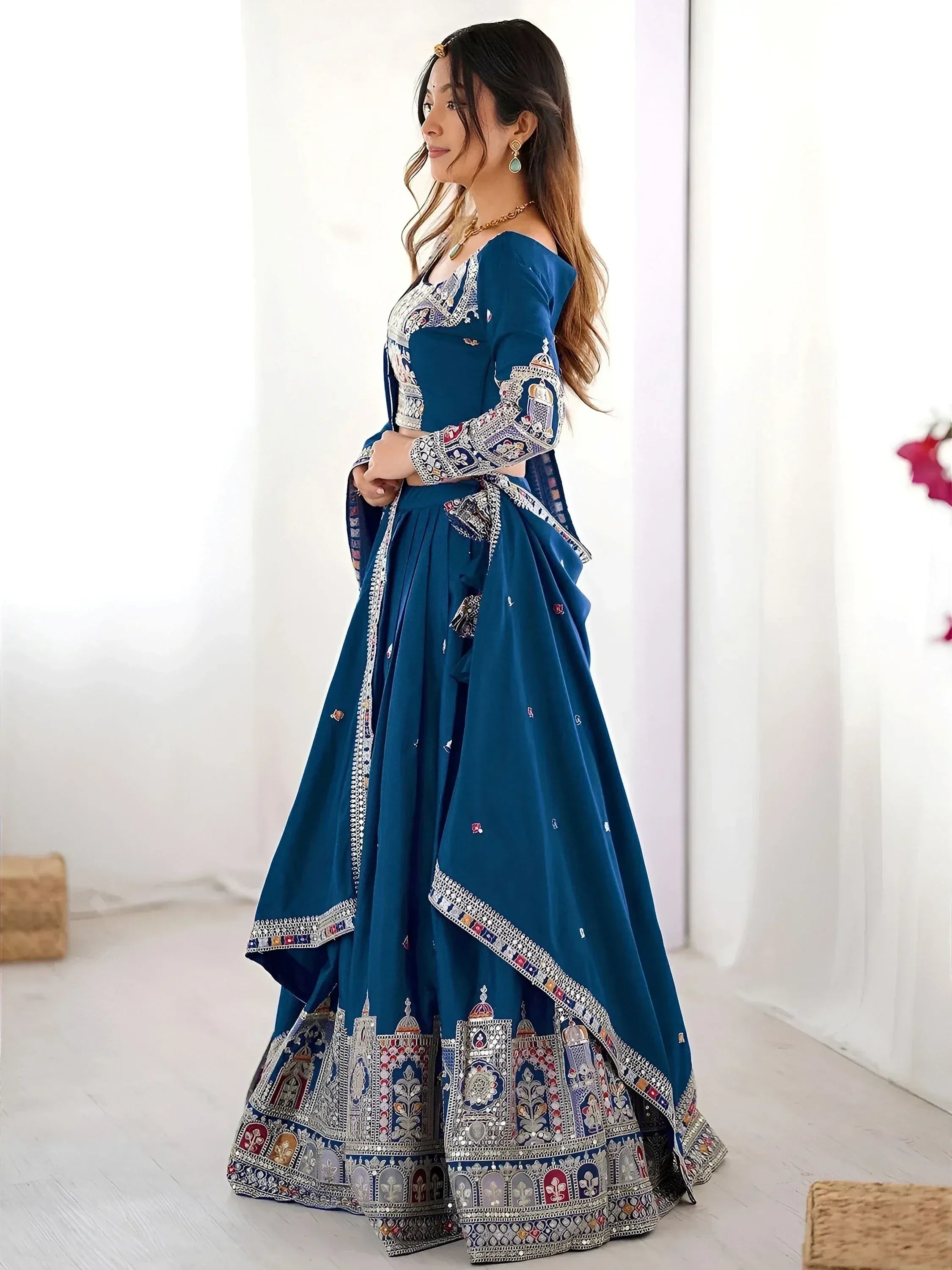 Blue designer lehenga choli with intricate embroidery and mirror work, perfect for Indian ethnic wear occasions.