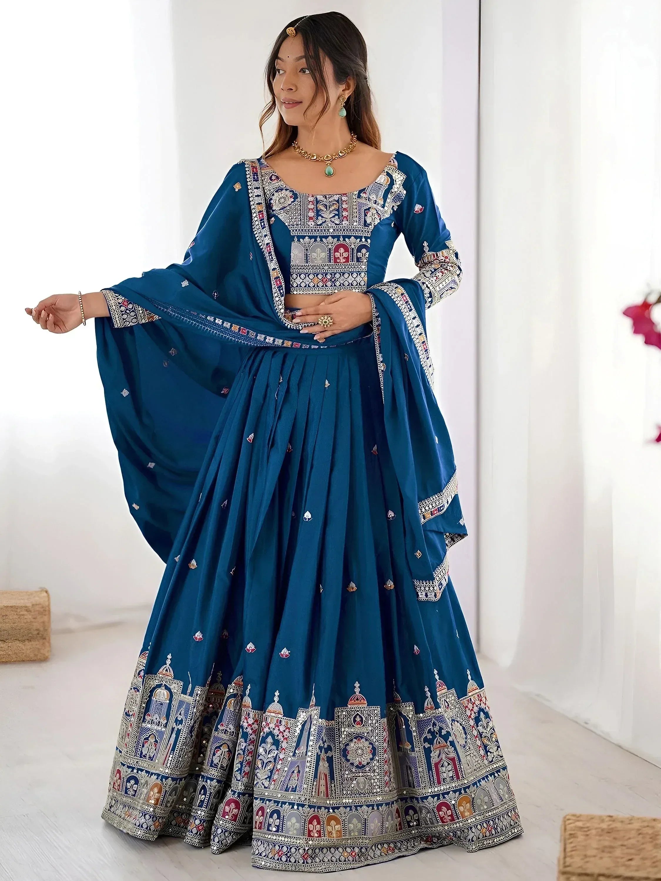 Blue embroidered lehenga choli with intricate temple motifs and mirror work, perfect for Indian ethnic occasions.