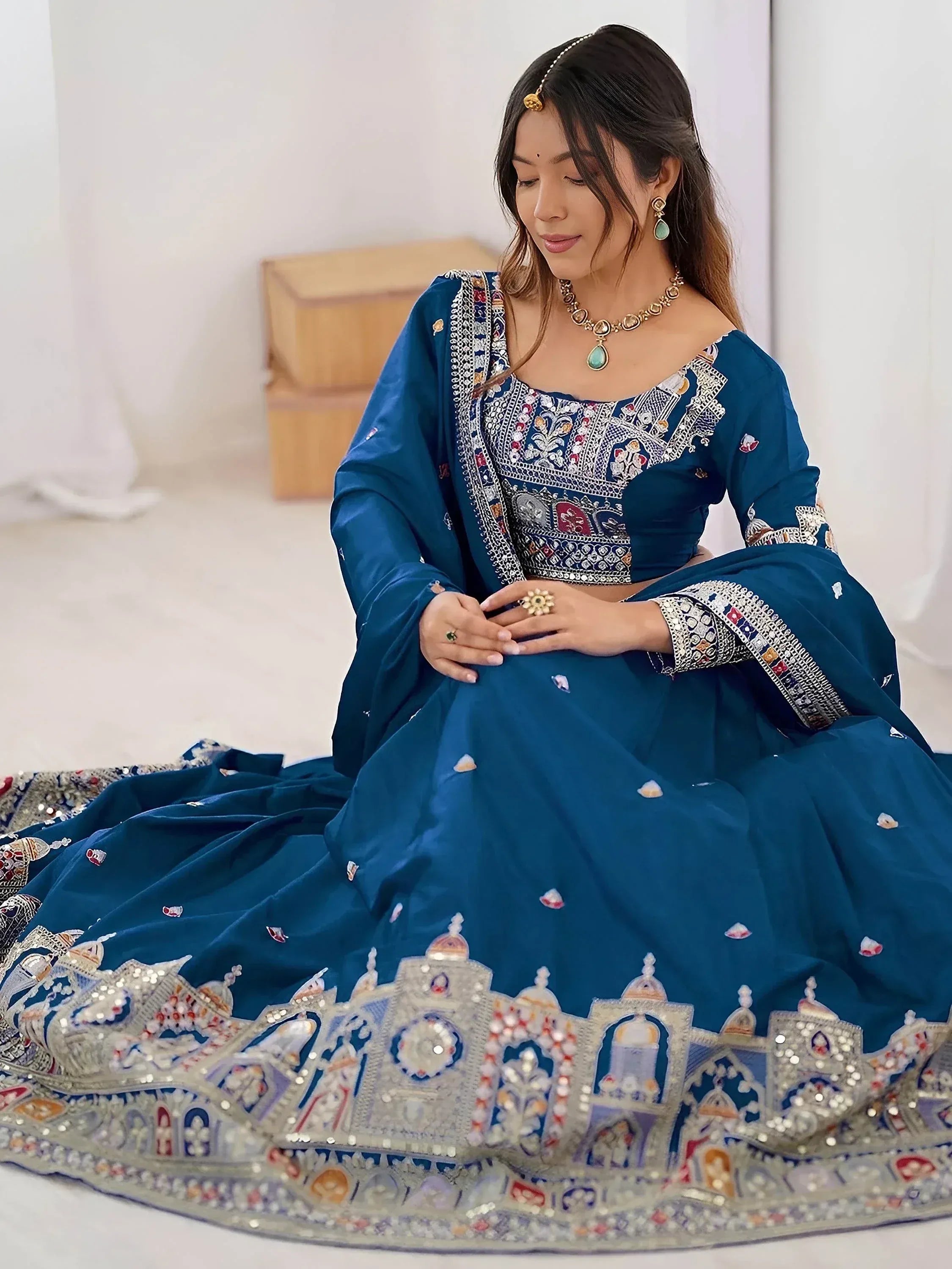 Teal blue designer lehenga choli with intricate temple embroidery and mirror work, perfect for Indian weddings