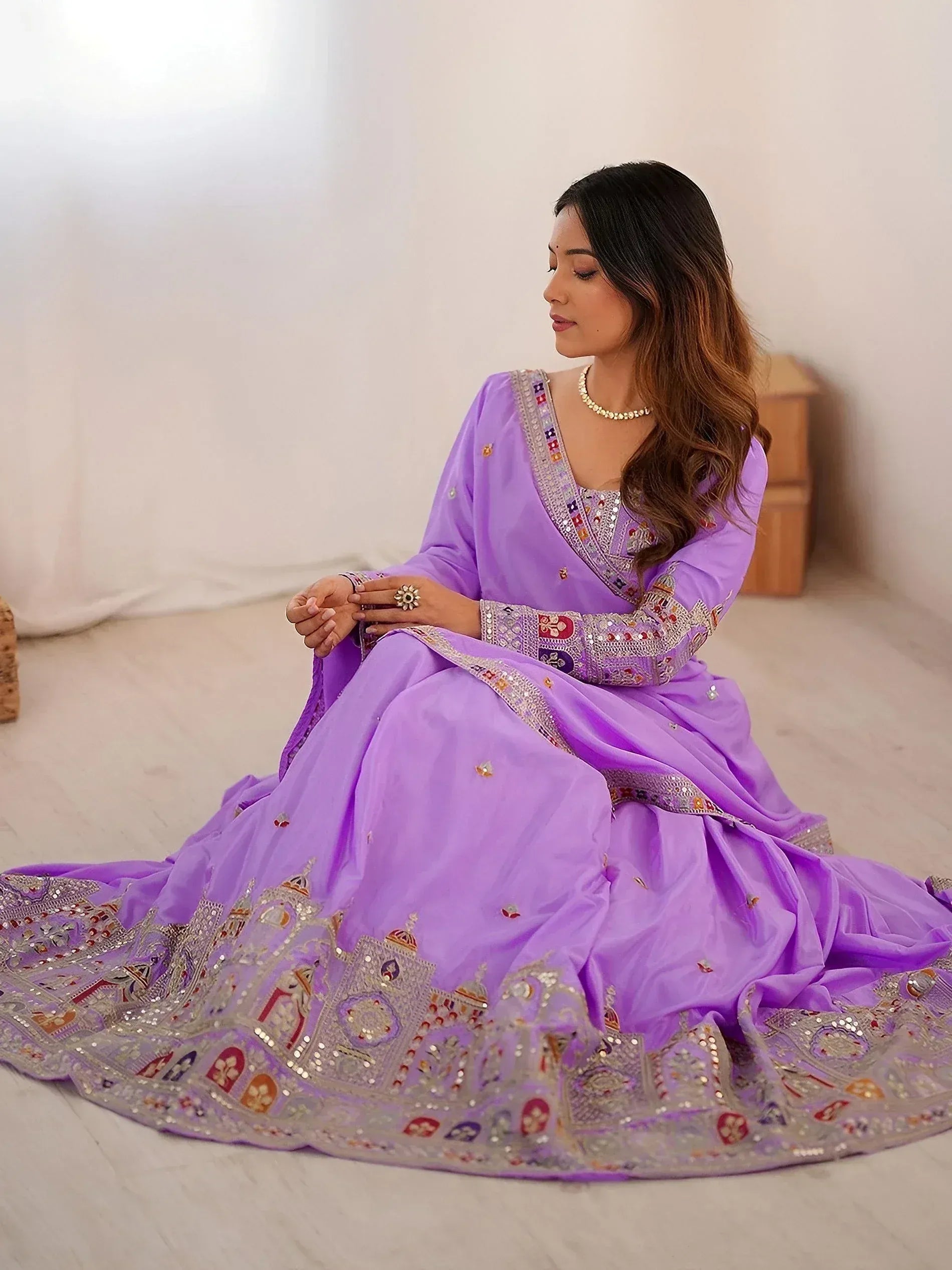 Woman in lavender designer lehenga choli with intricate embroidery and mirror work, perfect for Indian ethnic occasions