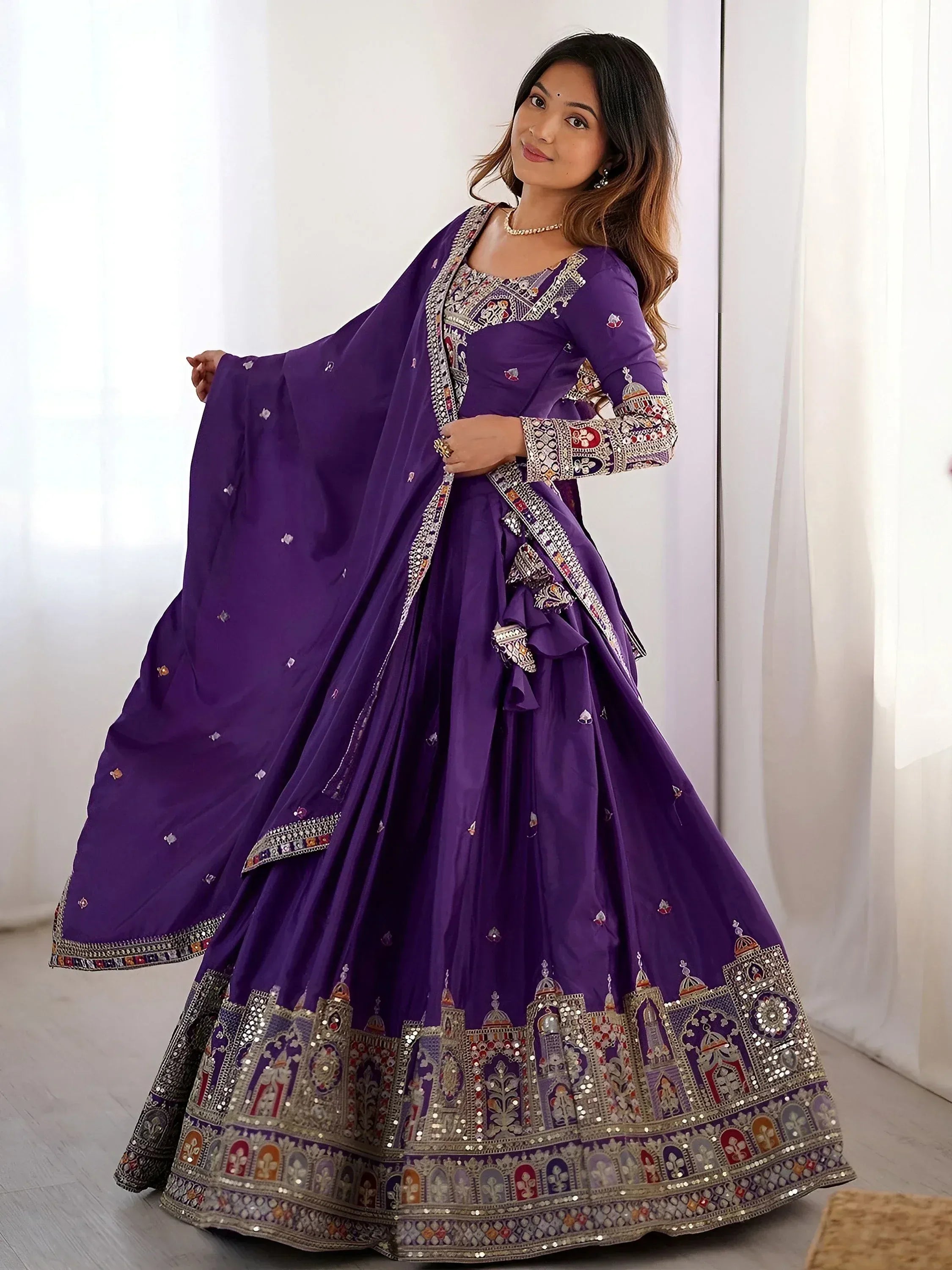 Purple designer lehenga choli with intricate embroidery and mirror work, perfect for Indian ethnic wear occasions.