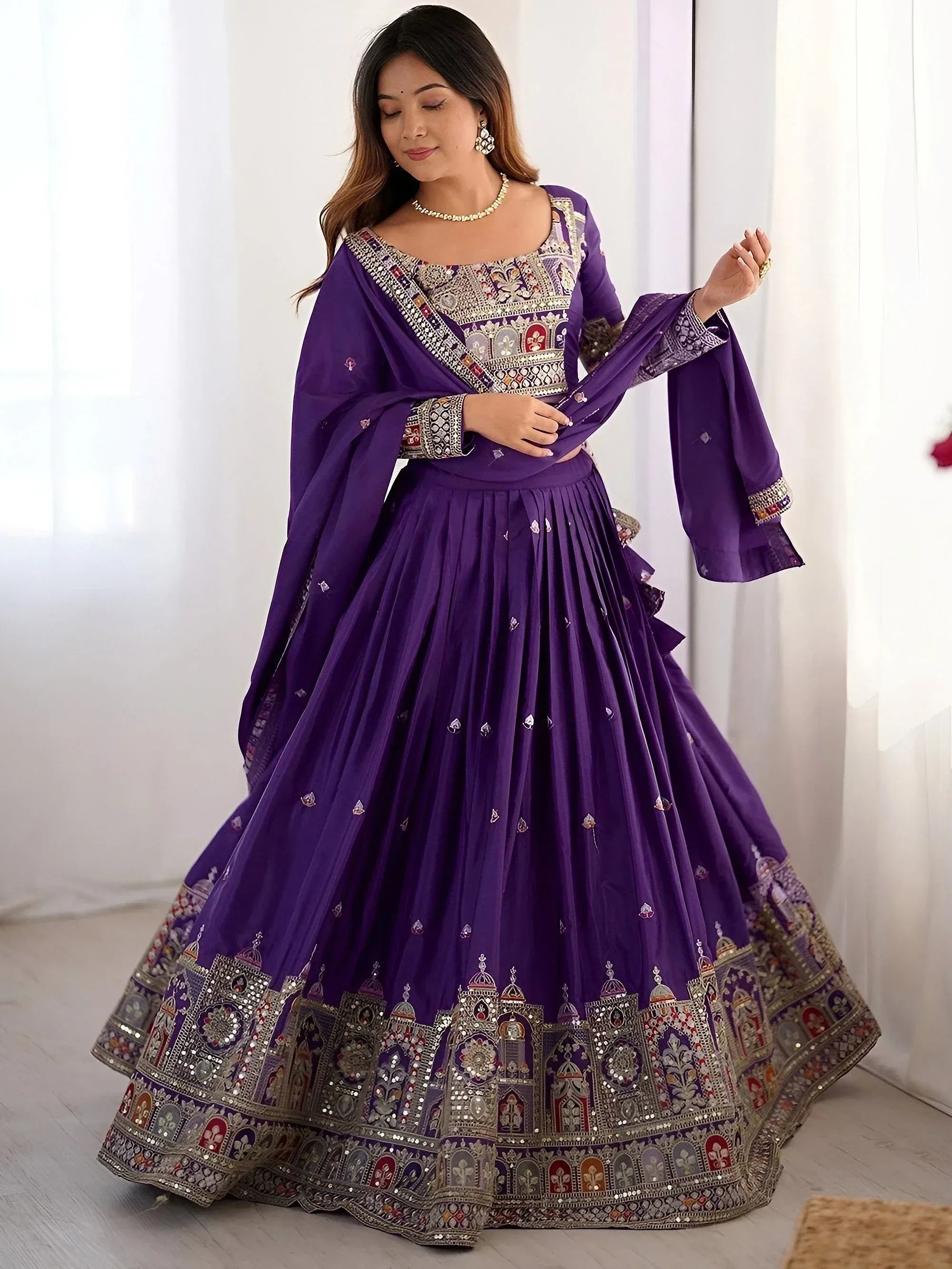 Purple designer lehenga choli with intricate embroidery and mirror work, perfect for Indian ethnic wear occasions.