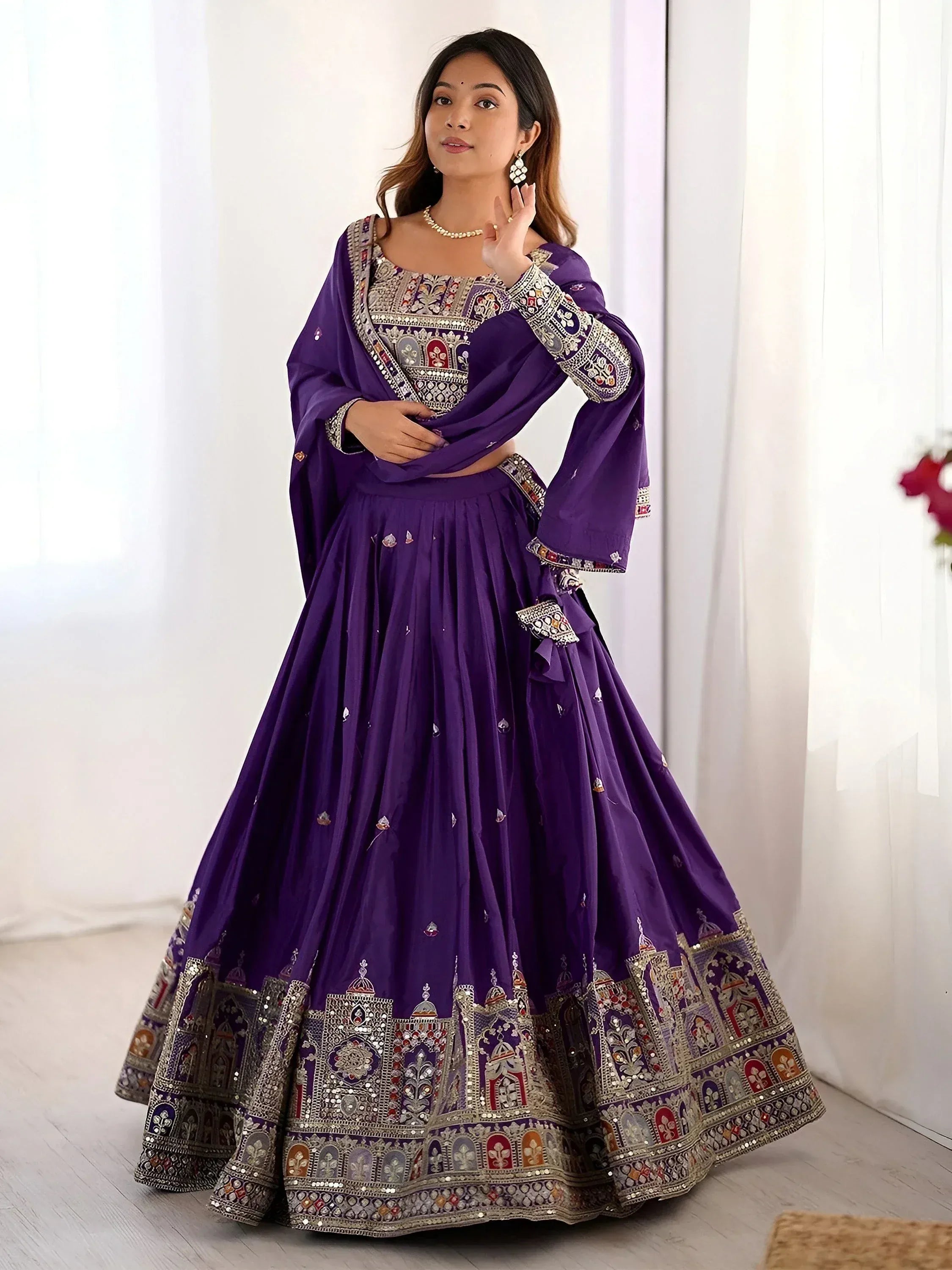 Purple designer lehenga choli with intricate embroidery and mirror work, perfect for Indian ethnic wear occasions.
