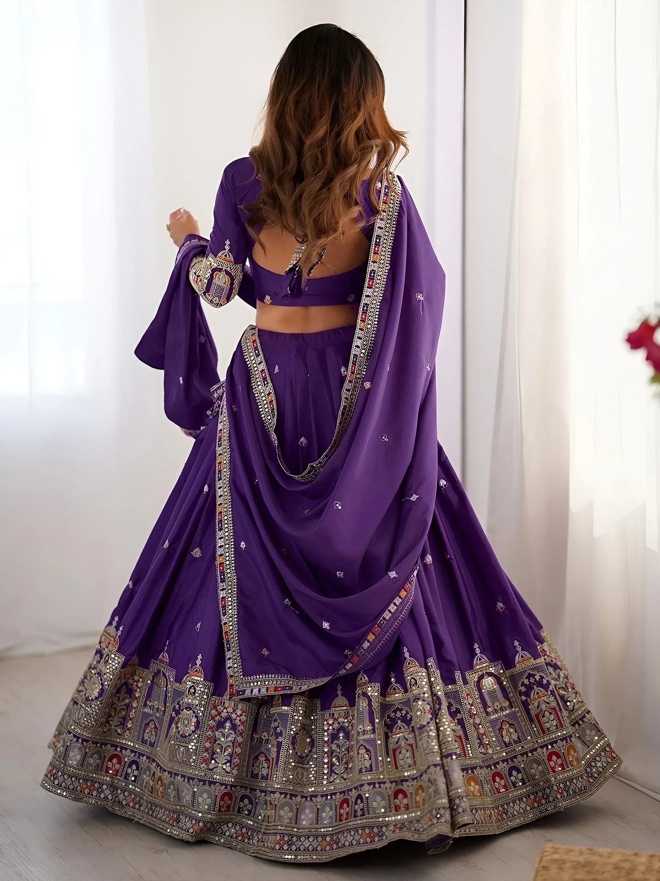 Purple designer lehenga choli with intricate embroidery and mirror work, perfect for Indian ethnic wear occasions.