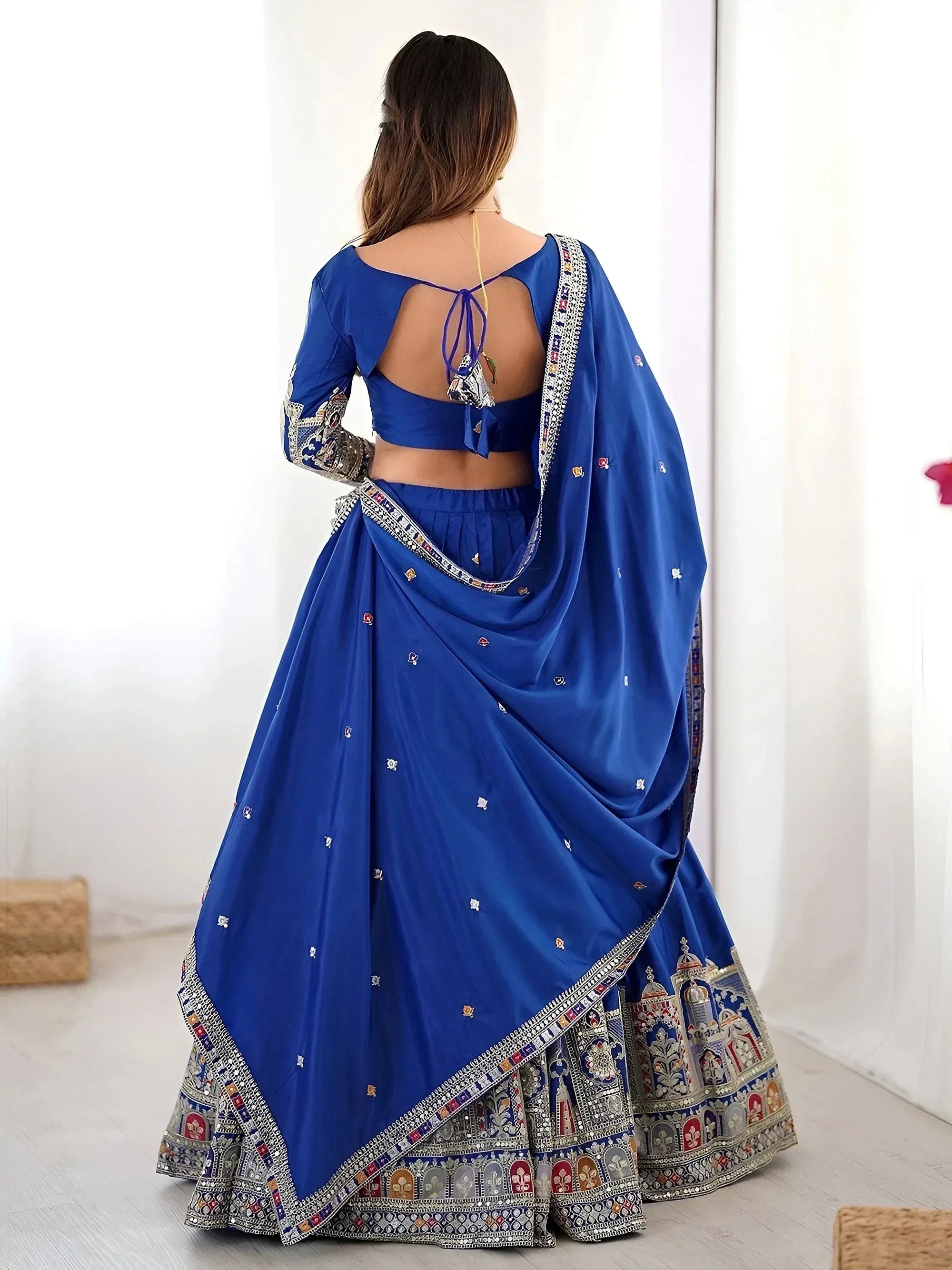 Royal blue designer lehenga choli with intricate embroidery and open back blouse, perfect for Indian weddings and festive occasions.