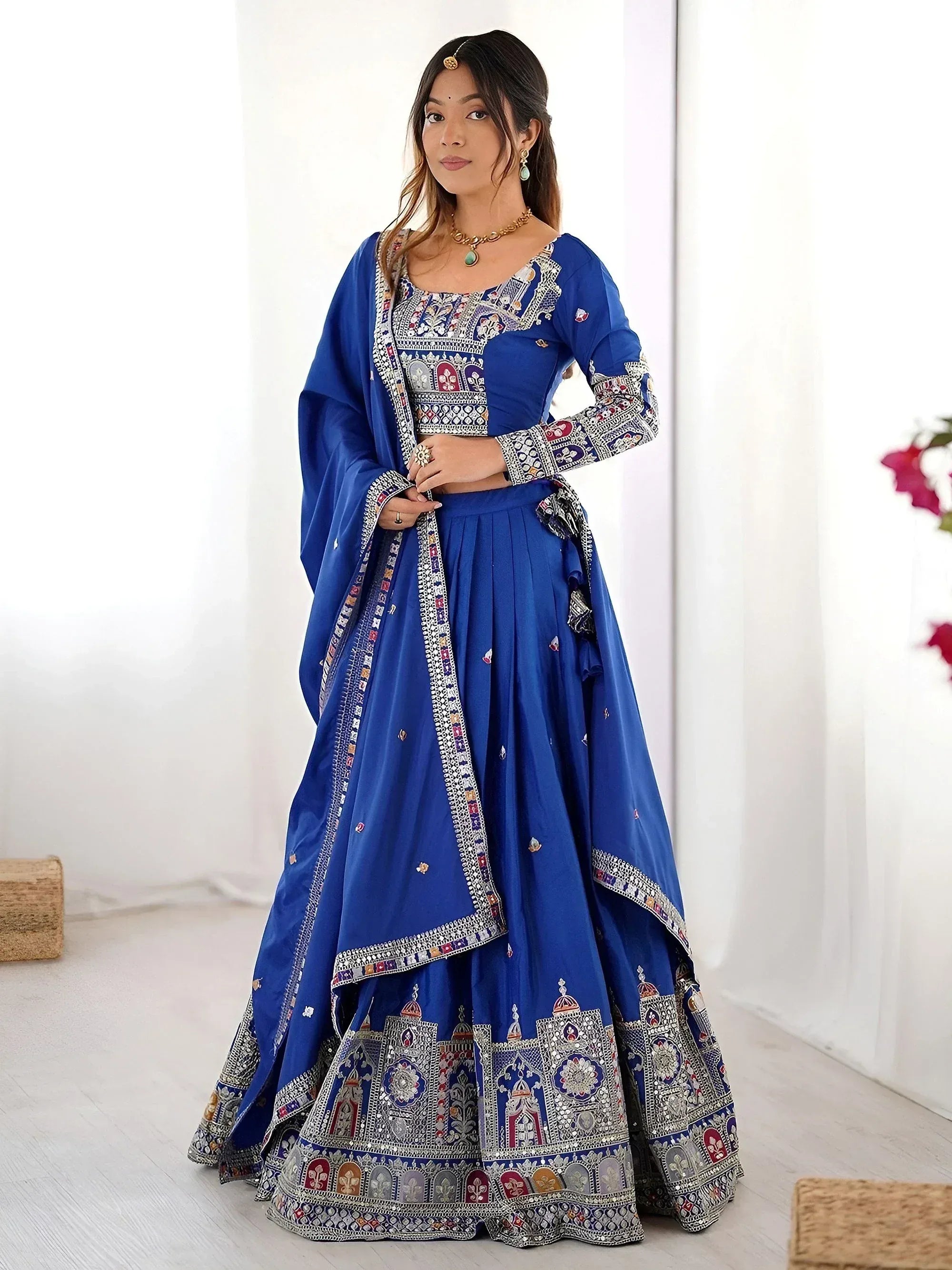Royal blue embroidered lehenga choli with intricate mirror work, perfect for Indian weddings and festive occasions.