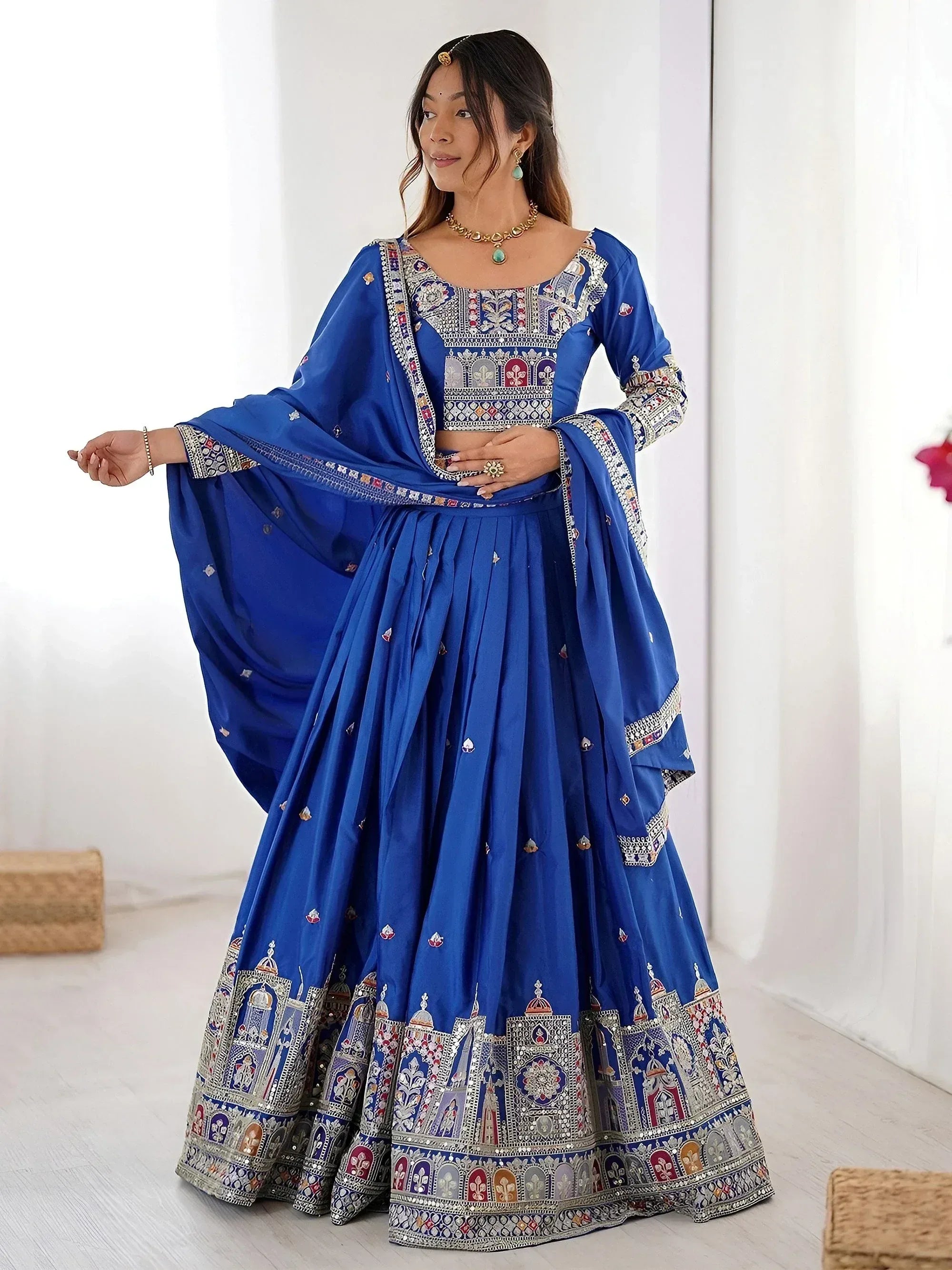 Royal blue designer lehenga choli with intricate embroidery and mirror work, perfect for Indian ethnic wear occasions.