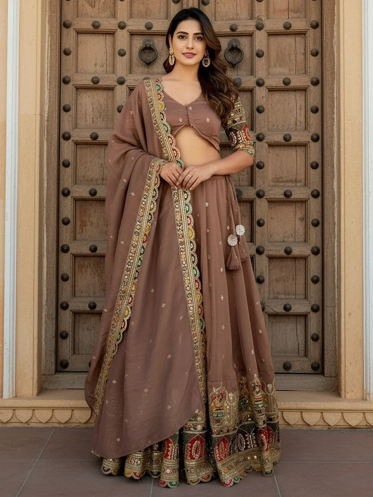 Elegant brown lehenga choli with intricate embroidery and mirror work, perfect for Indian ethnic wear occasions.