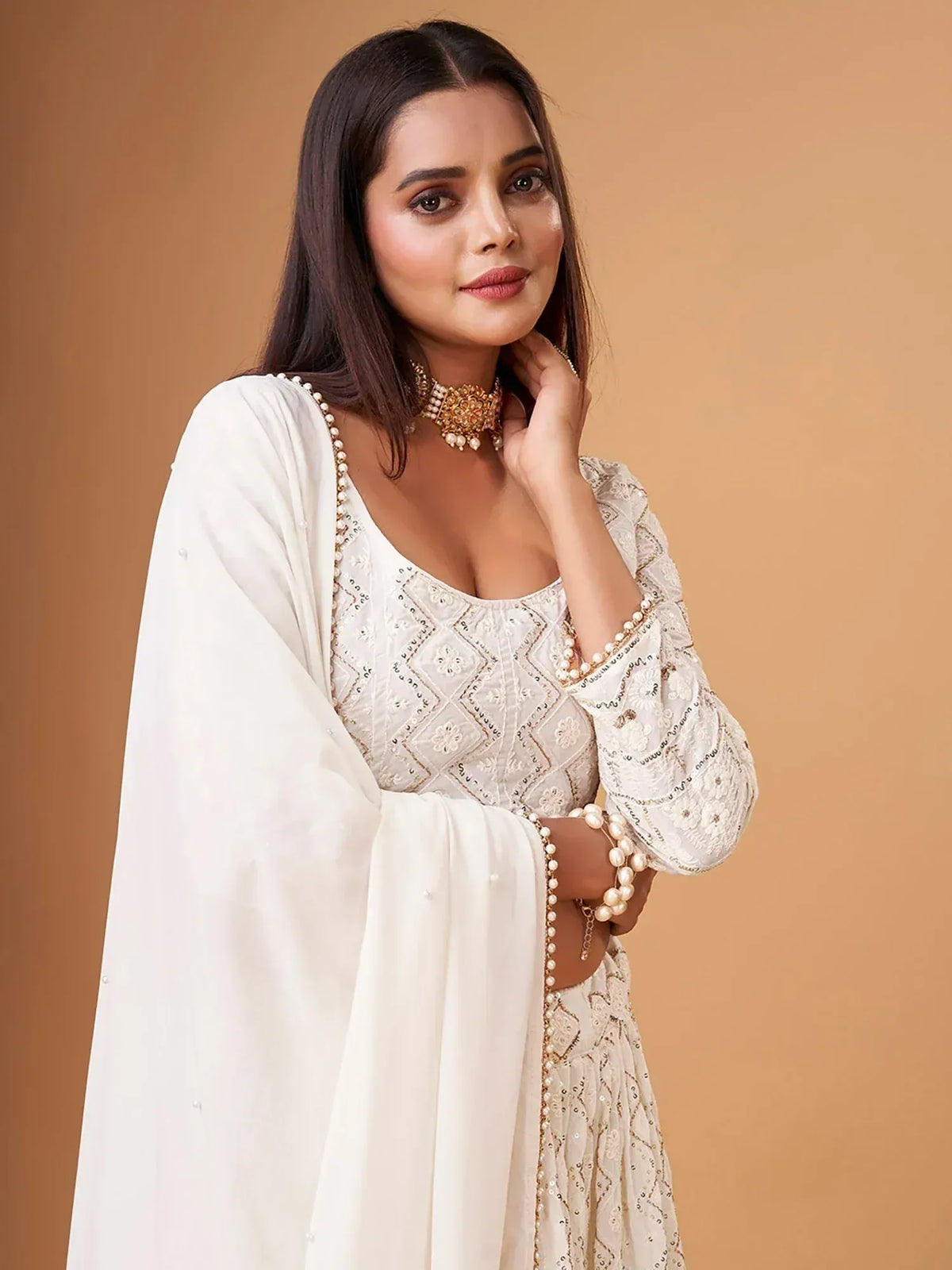 Elegant white embroidered salwar kameez with pearl detailing and matching dupatta, perfect for ethnic occasions.