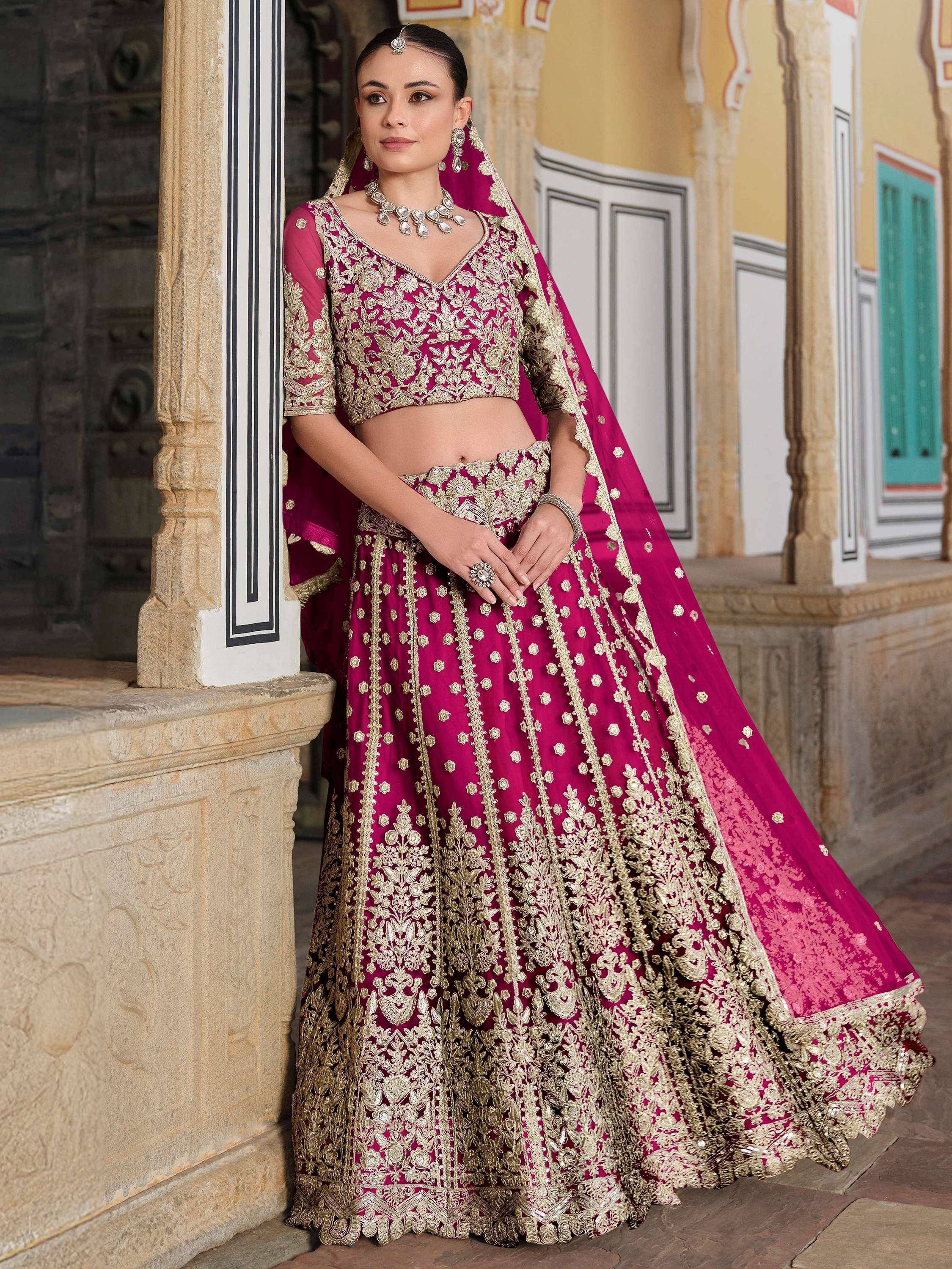Elegant magenta lehenga choli with gold embroidery, perfect for Indian weddings and festive occasions.