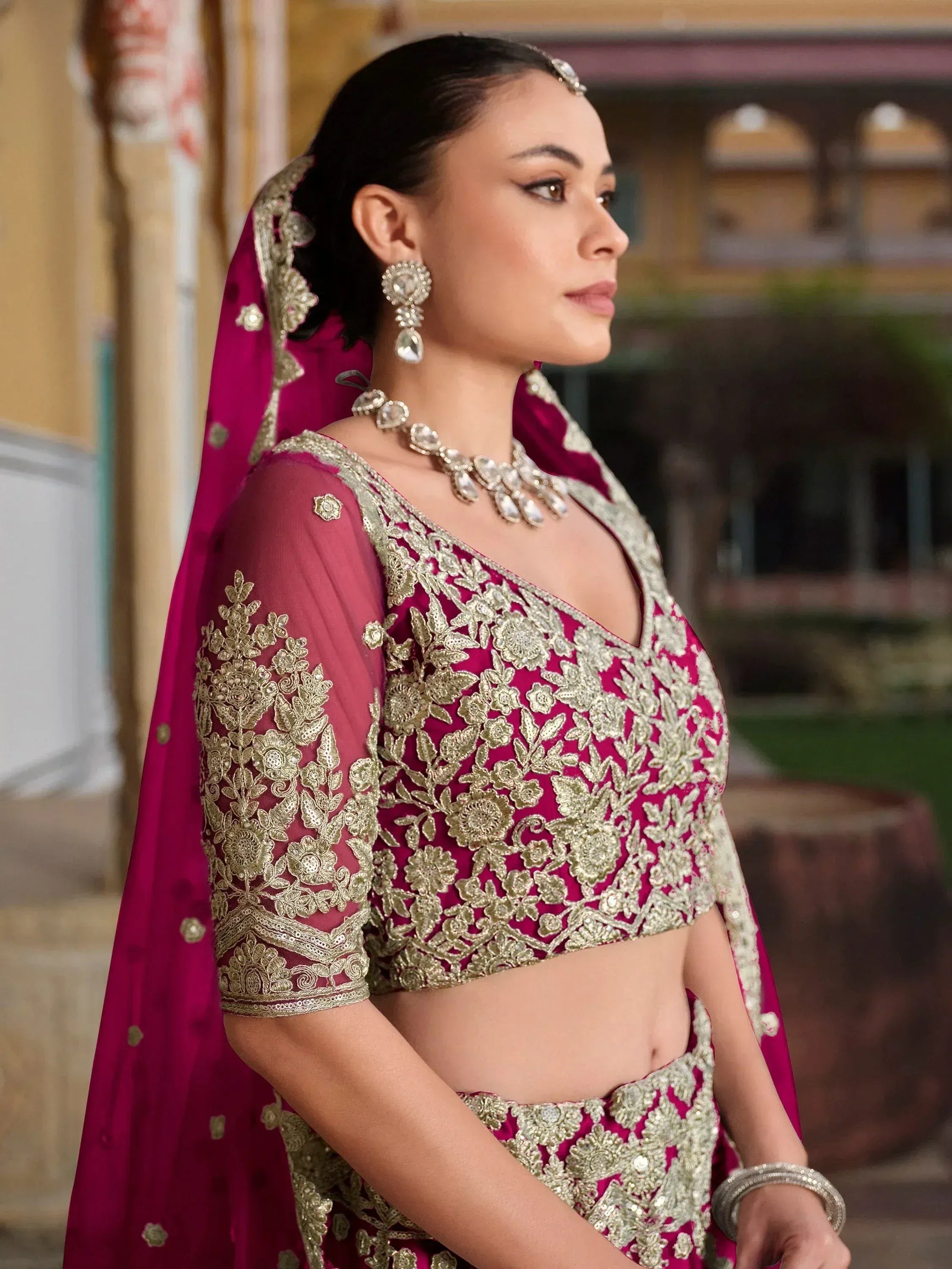 Elegant magenta lehenga choli with gold embroidery, perfect for Indian weddings and festive occasions.