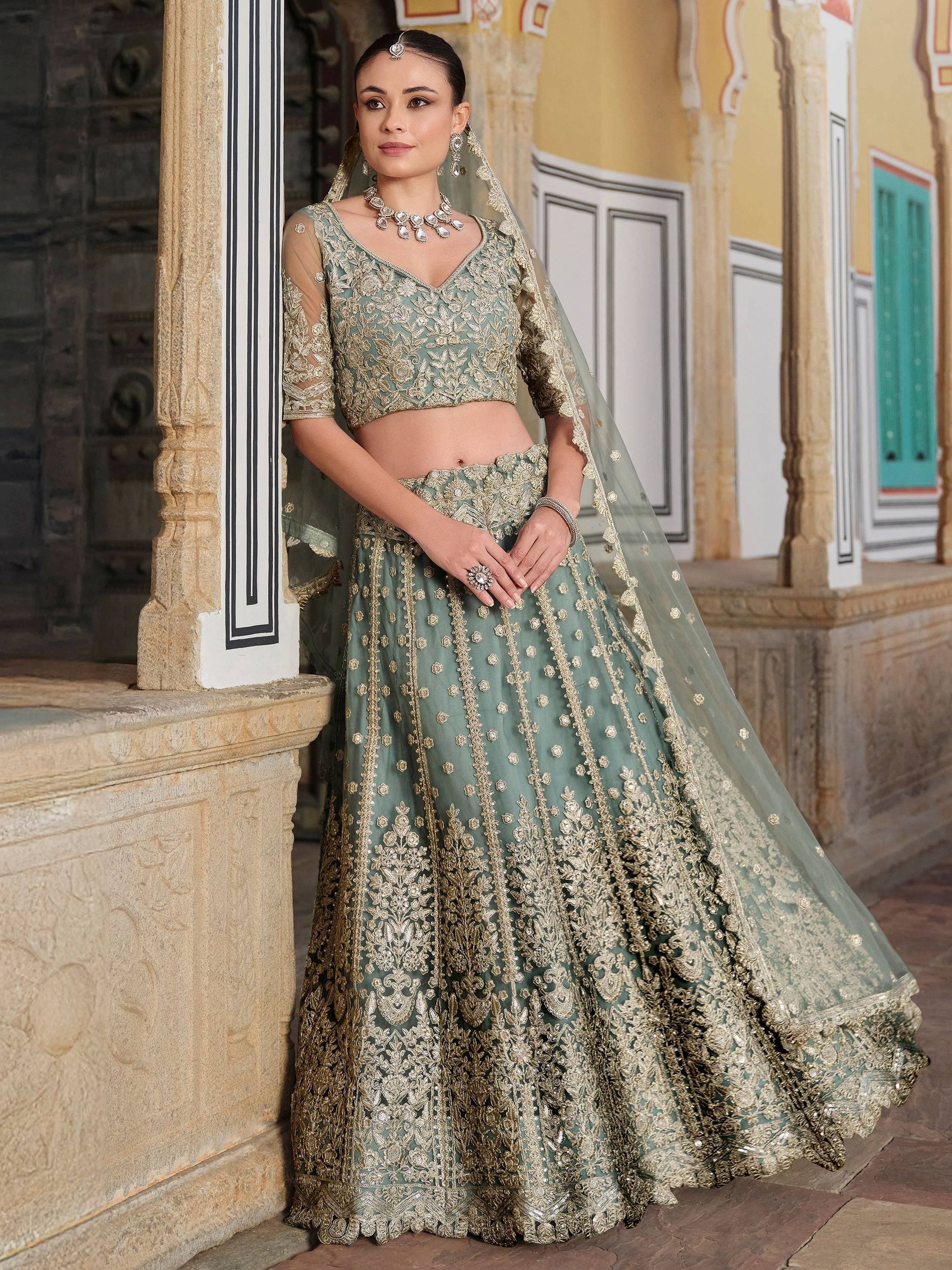 Elegant sage green lehenga choli with gold embroidery, perfect for Indian weddings and festive occasions.