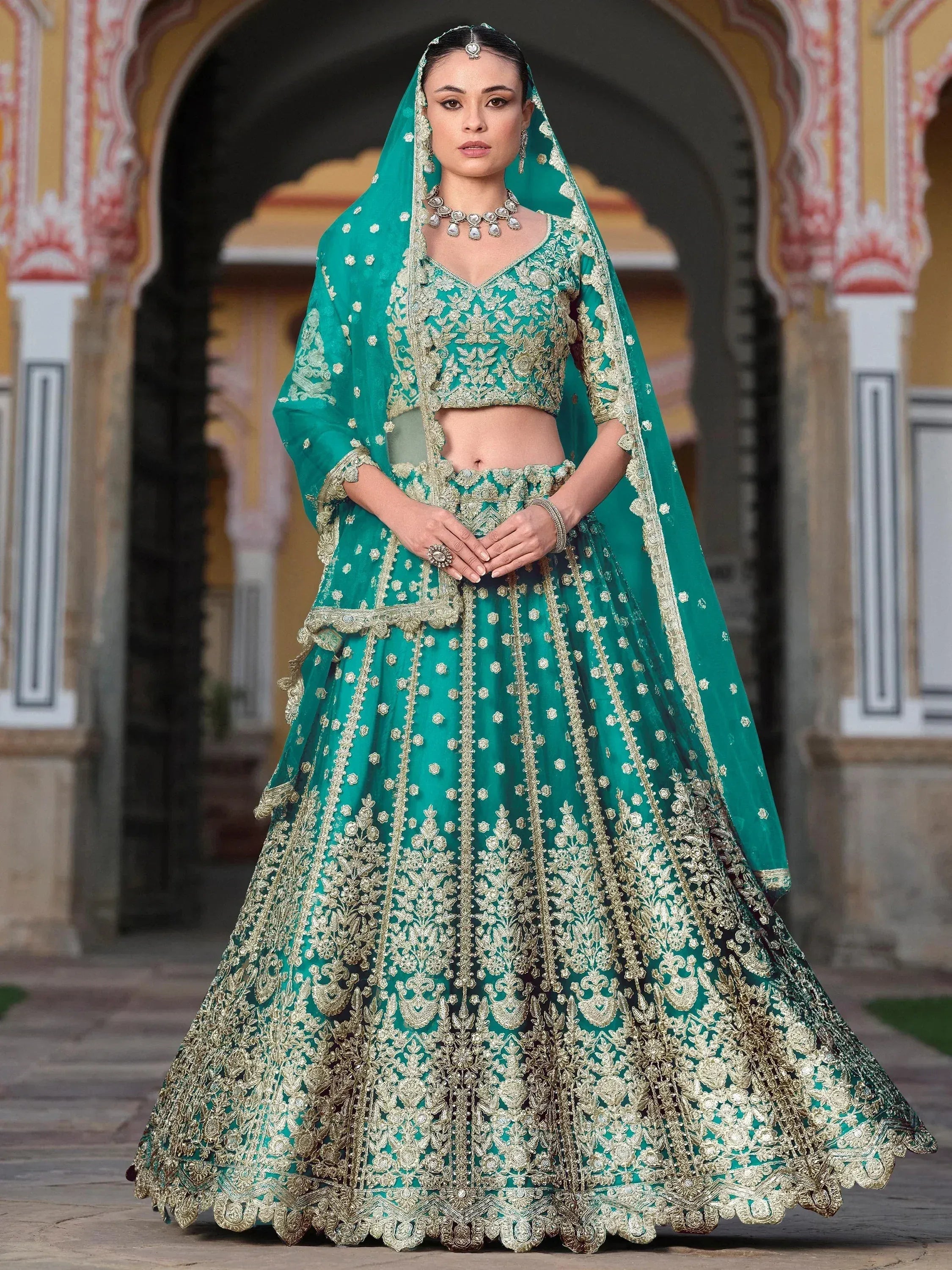 Emerald green designer lehenga choli with gold embroidery, perfect for Indian weddings and festive occasions.