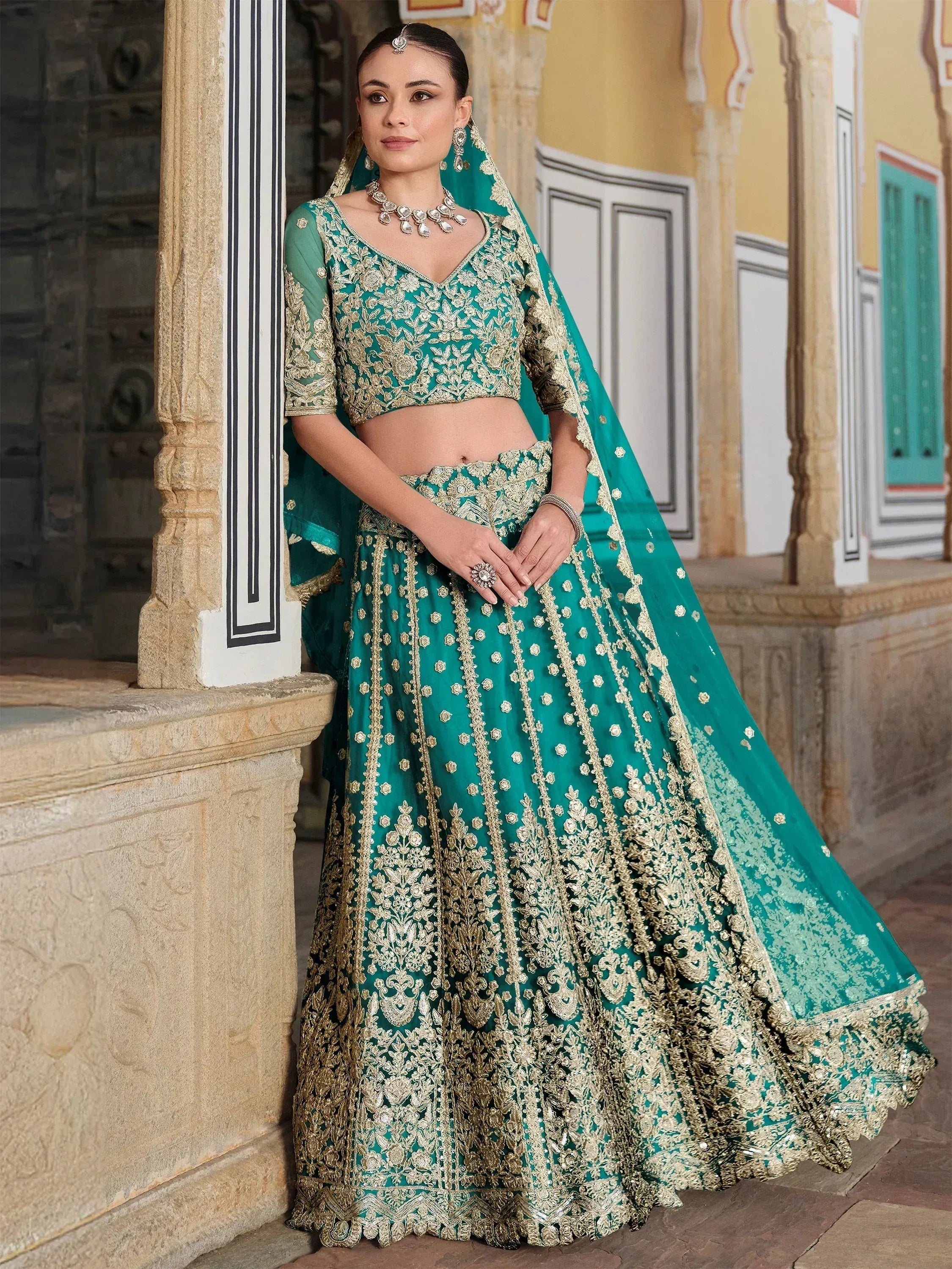 Teal green designer lehenga choli with gold embroidery, perfect for Indian weddings and festive occasions