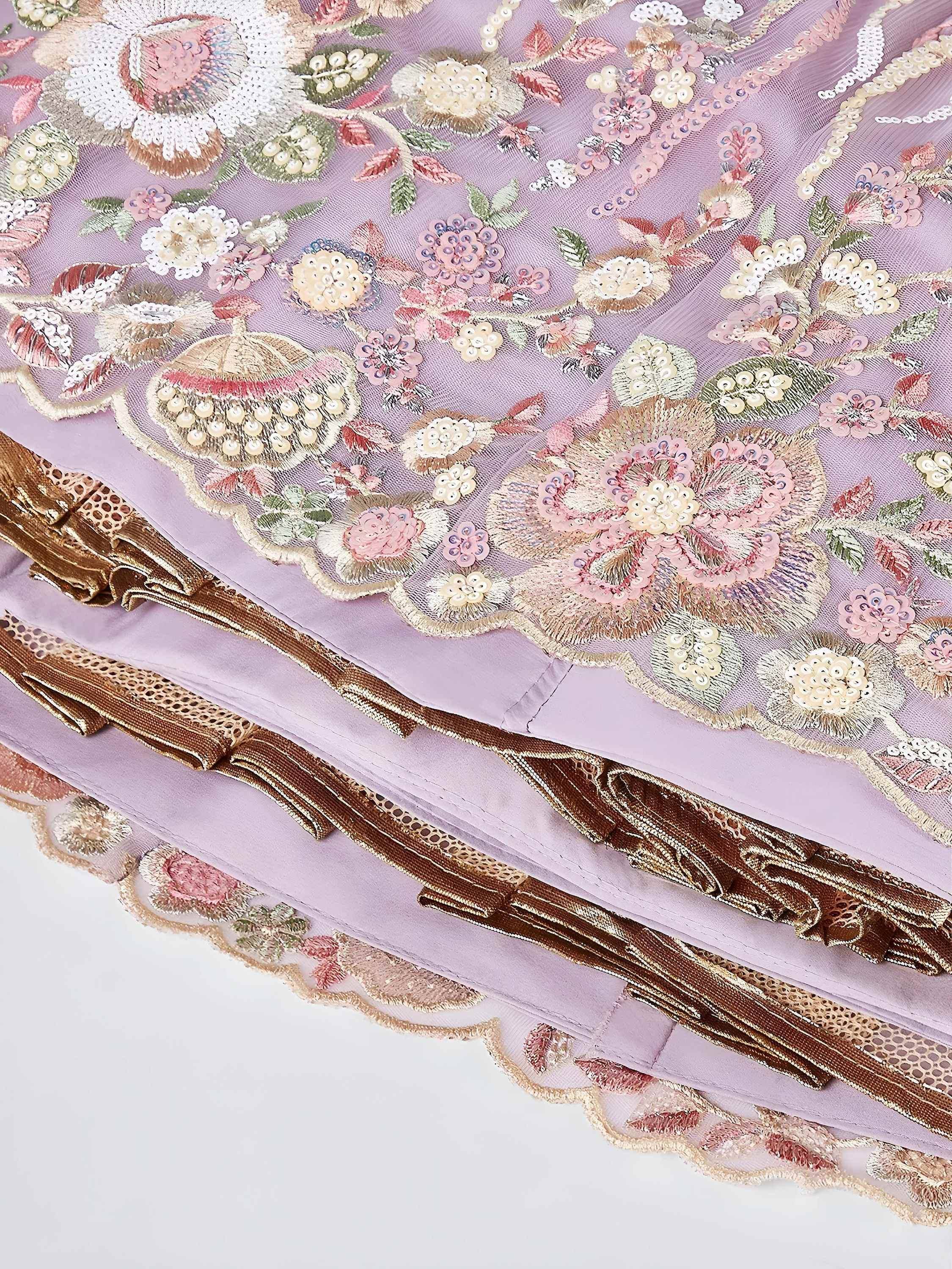 Lavender ethnic gown with floral embroidery, sequins, and gold trim detailing for festive occasions.