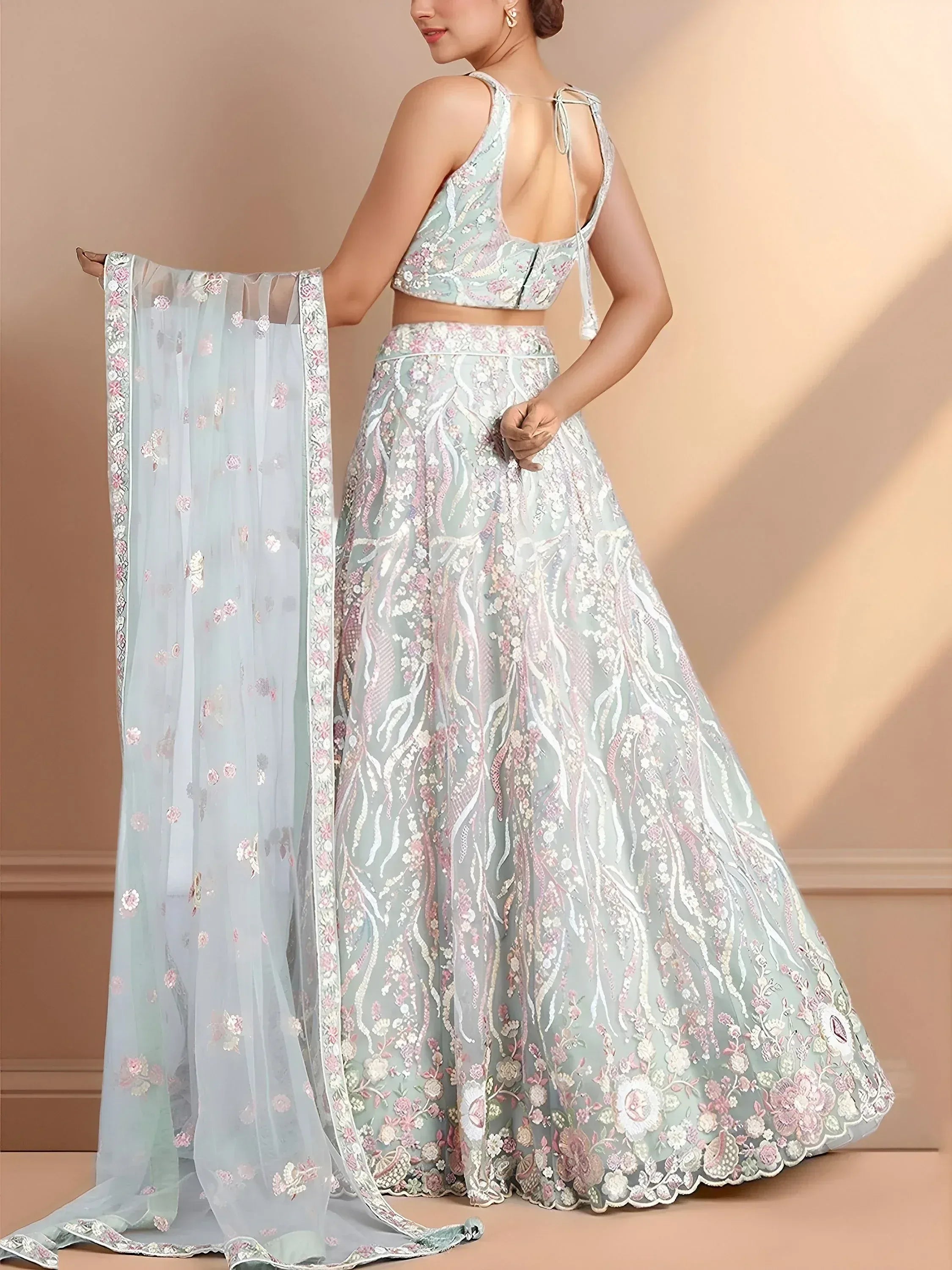 Pastel blue designer lehenga choli with floral embroidery and sheer dupatta, perfect for weddings or festive occasions.