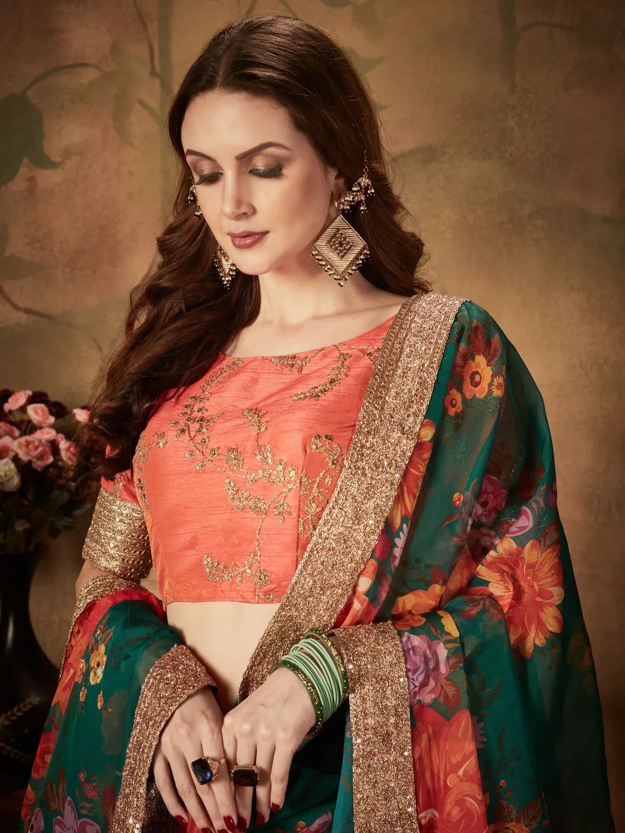 Woman in coral embroidered blouse with green floral dupatta, gold jewelry, Indian ethnic wear
