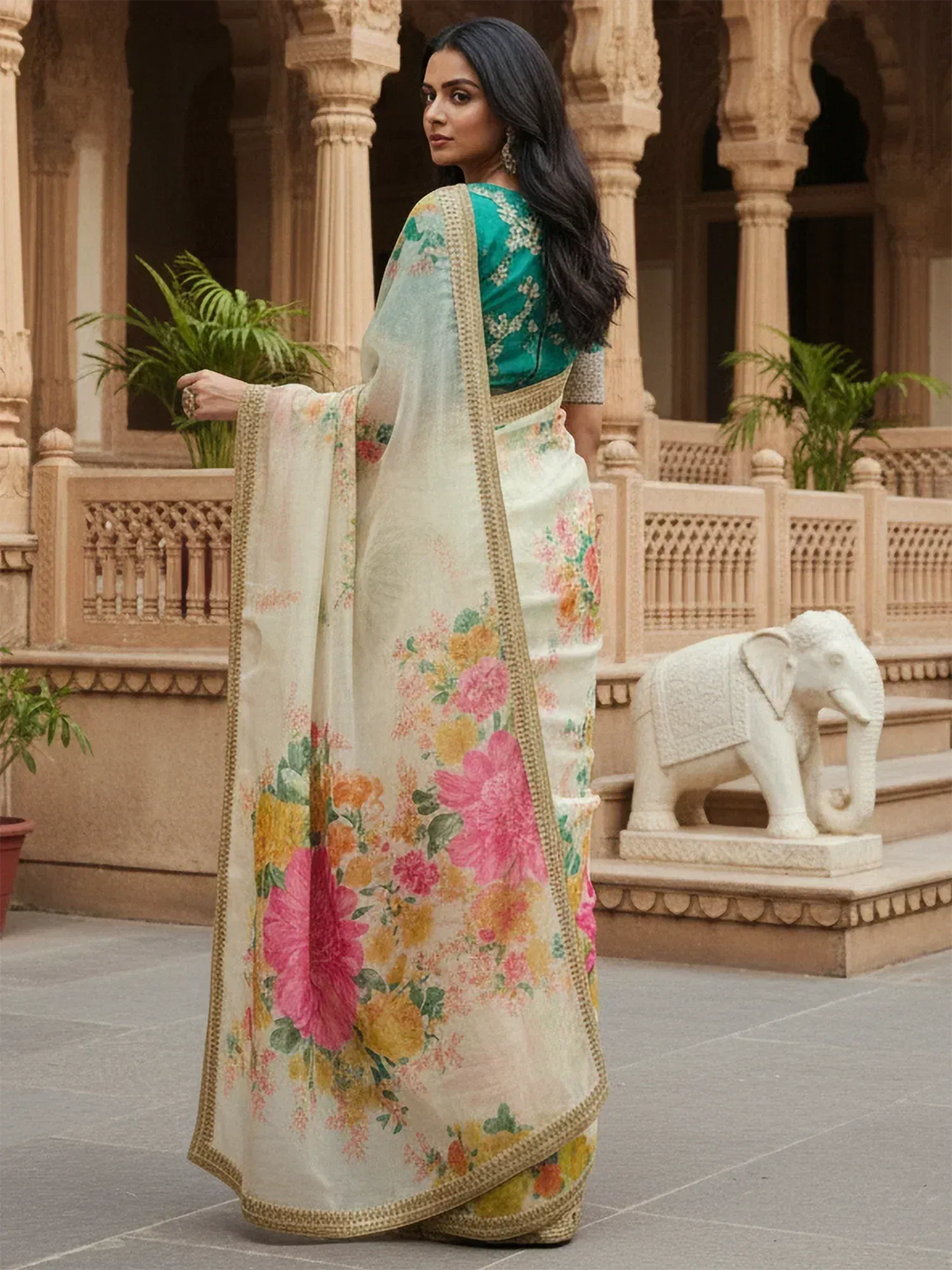 Woman in floral print saree with green blouse, traditional Indian ethnic wear, palace courtyard setting