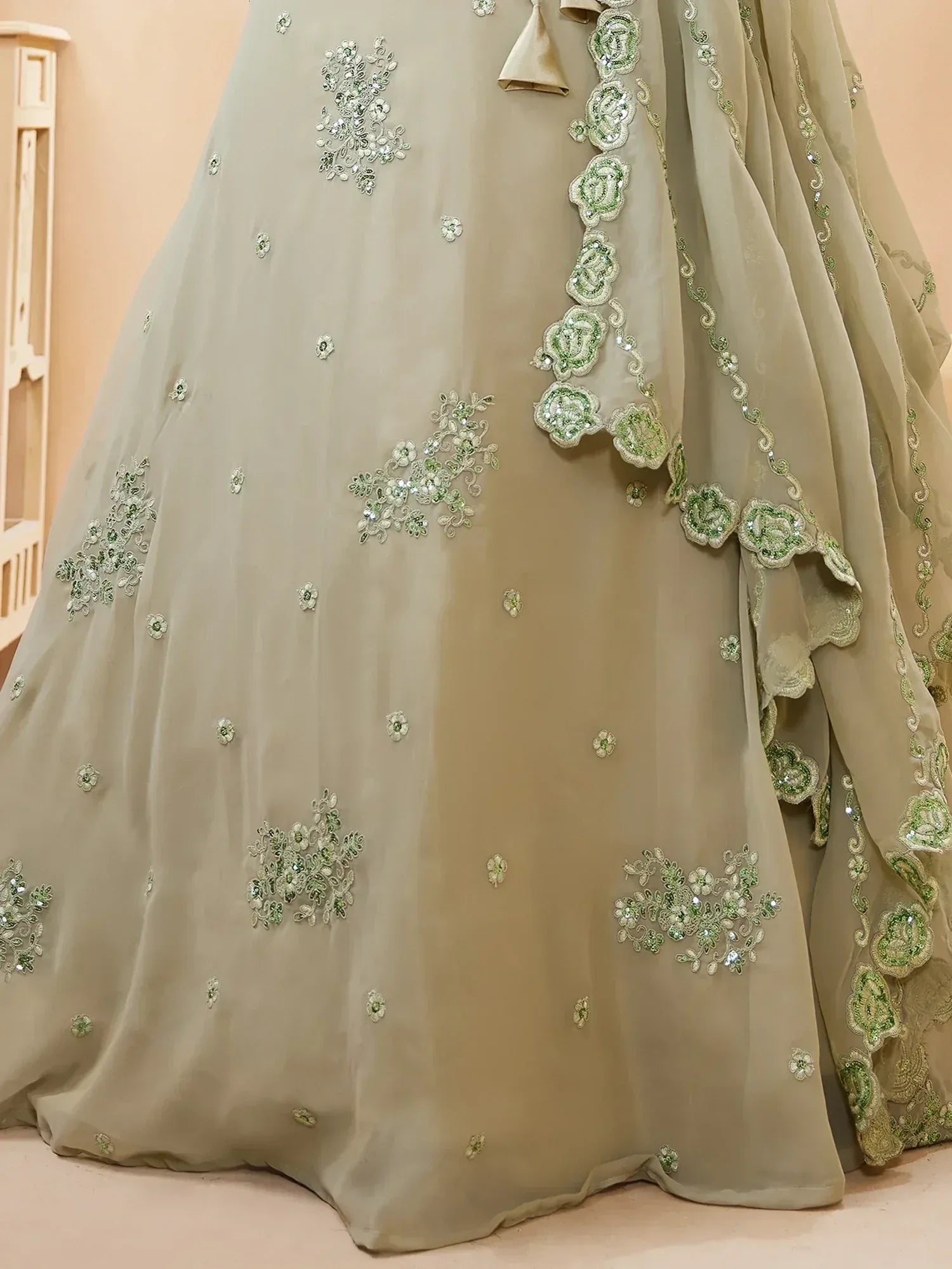 Elegant beige lehenga with green floral embroidery and sequin detailing for Indian ethnic wear