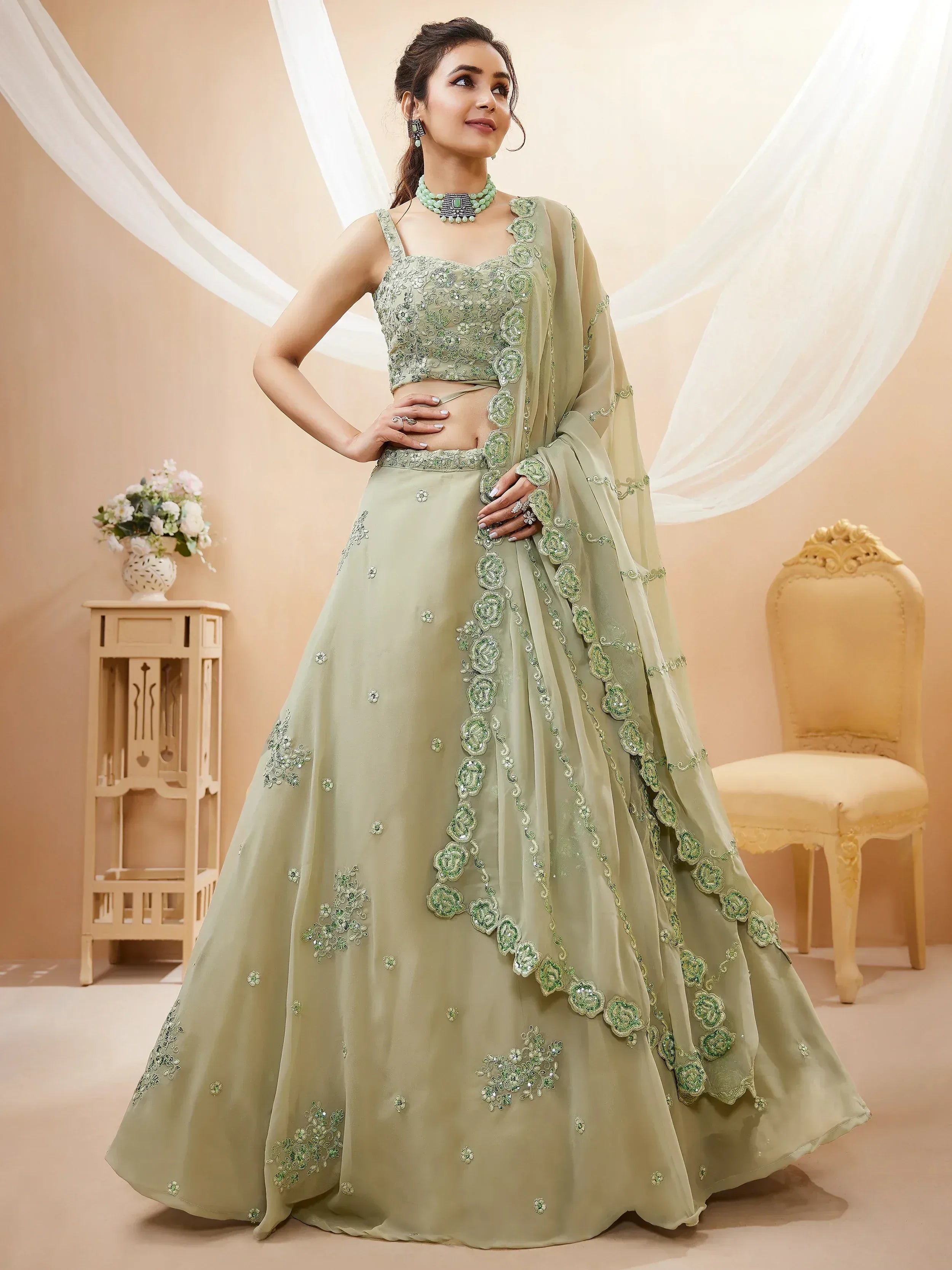 Mint green embroidered lehenga choli with floral embellishments, perfect for weddings and festive occasions.