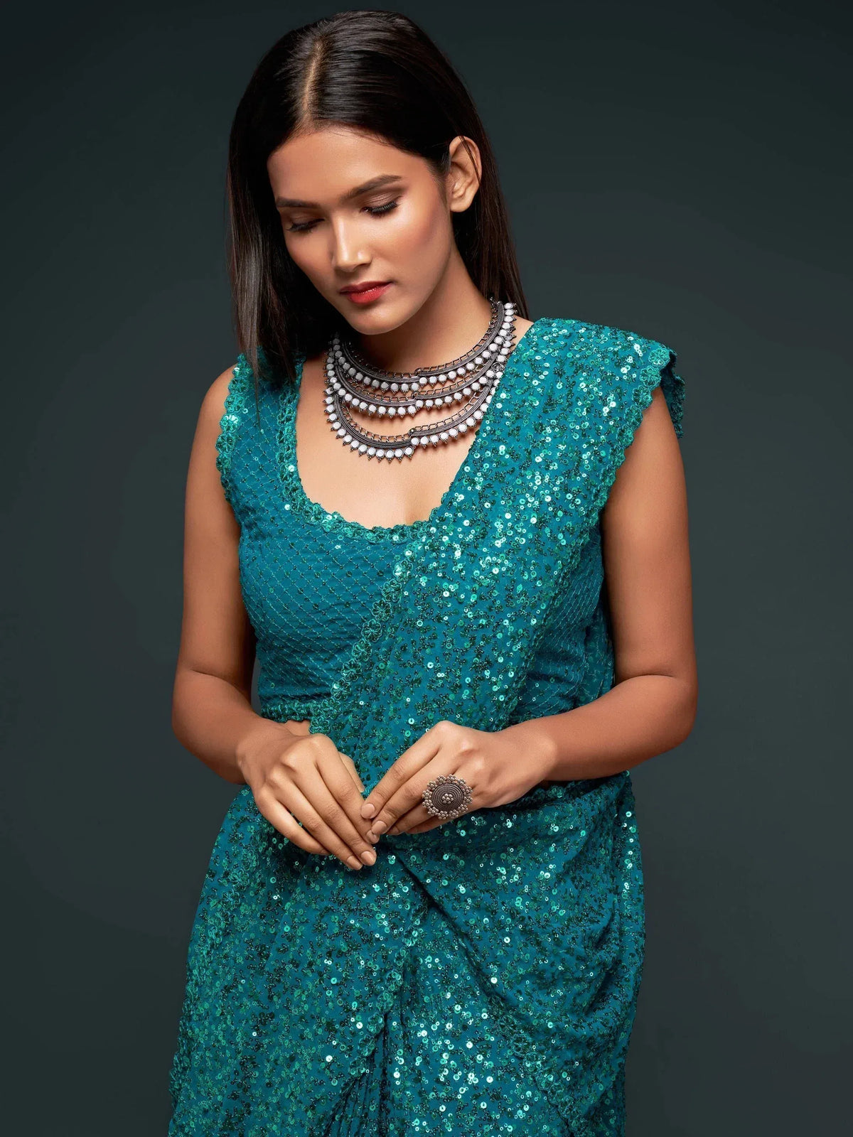 Teal sequin ethnic gown with layered necklace, perfect for Indian festive occasions