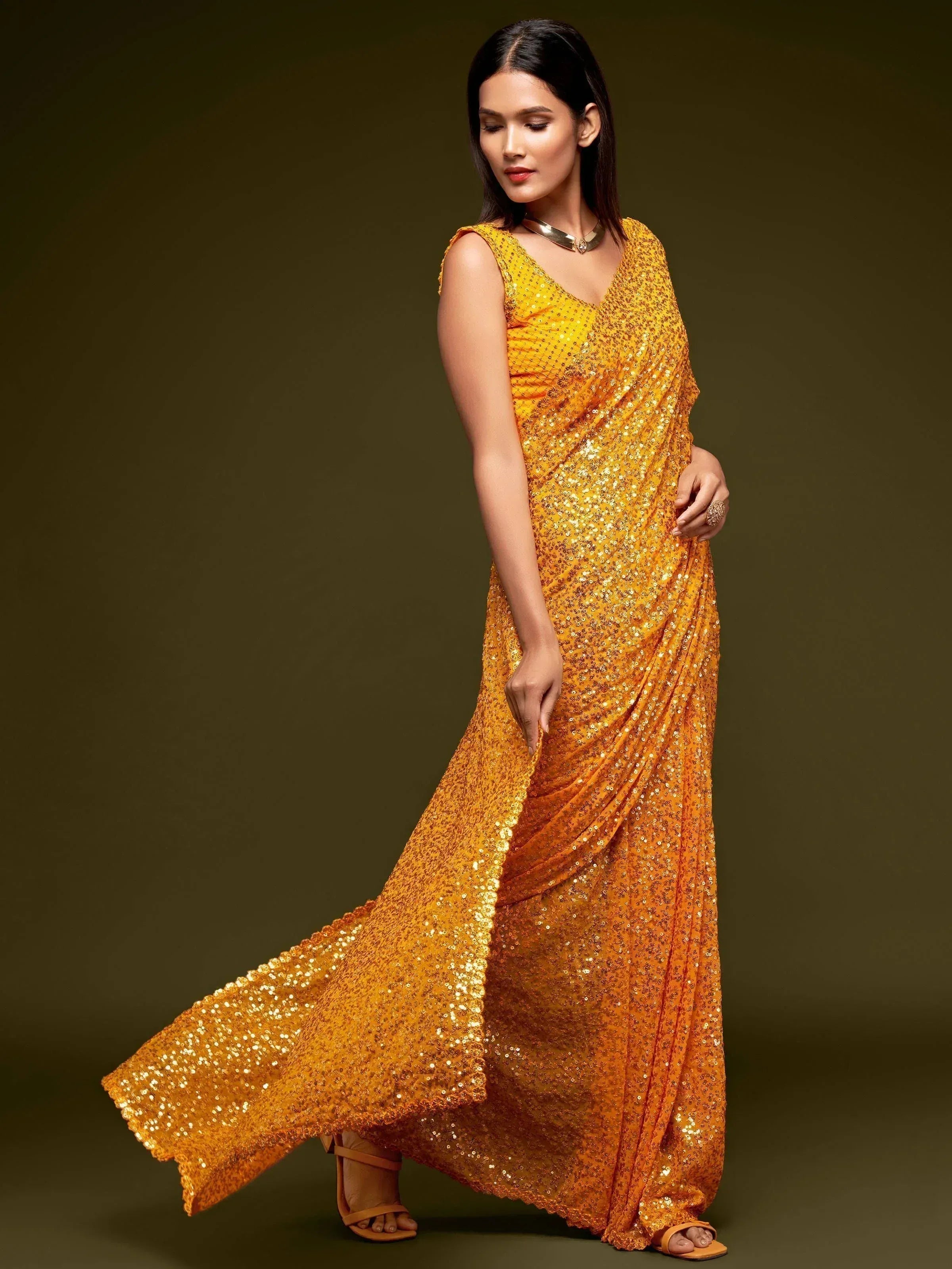 Woman in shimmering gold sequin ethnic gown, perfect for festive occasions and parties.