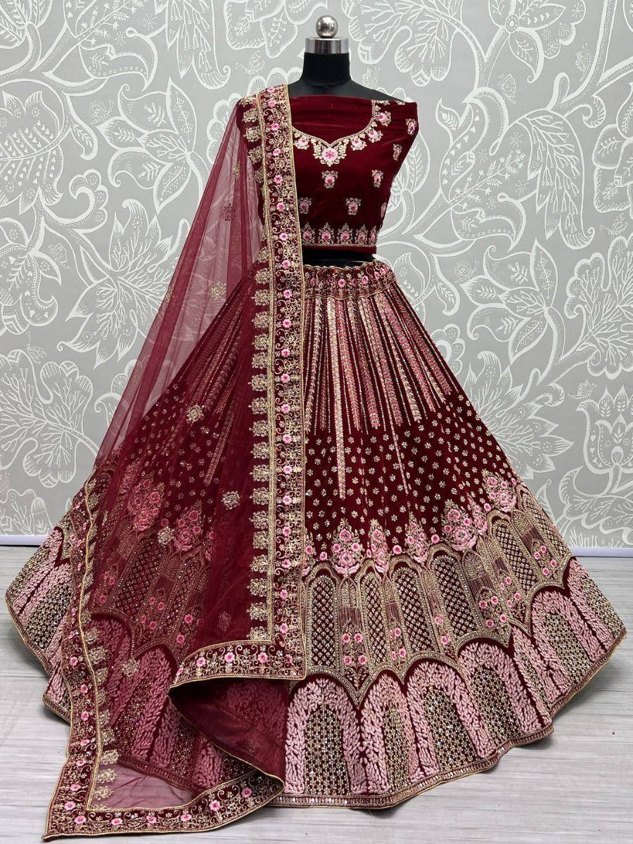 Maroon velvet lehenga choli with gold and pink embroidery, perfect for weddings and festive occasions.