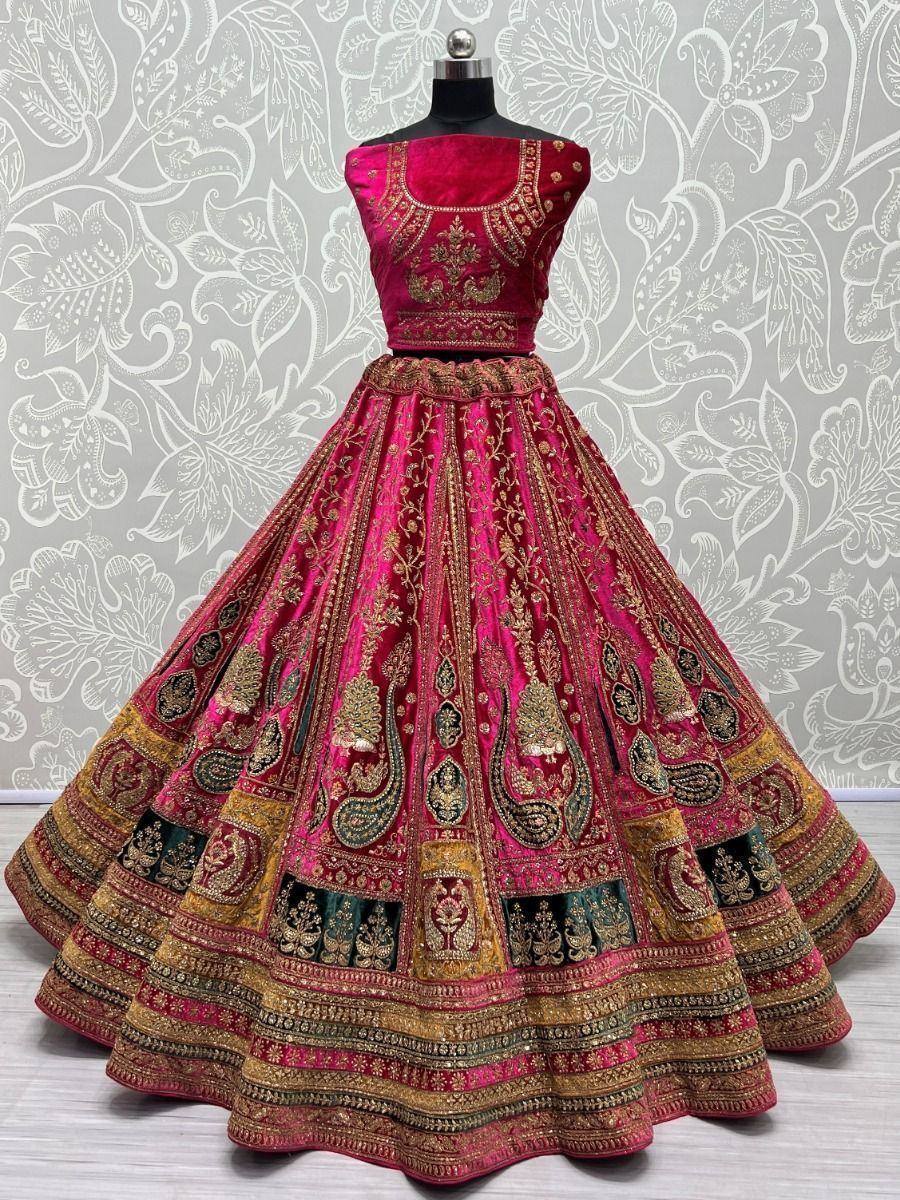 Fuchsia velvet lehenga choli with gold and black embroidery, perfect for Indian weddings and festive occasions.