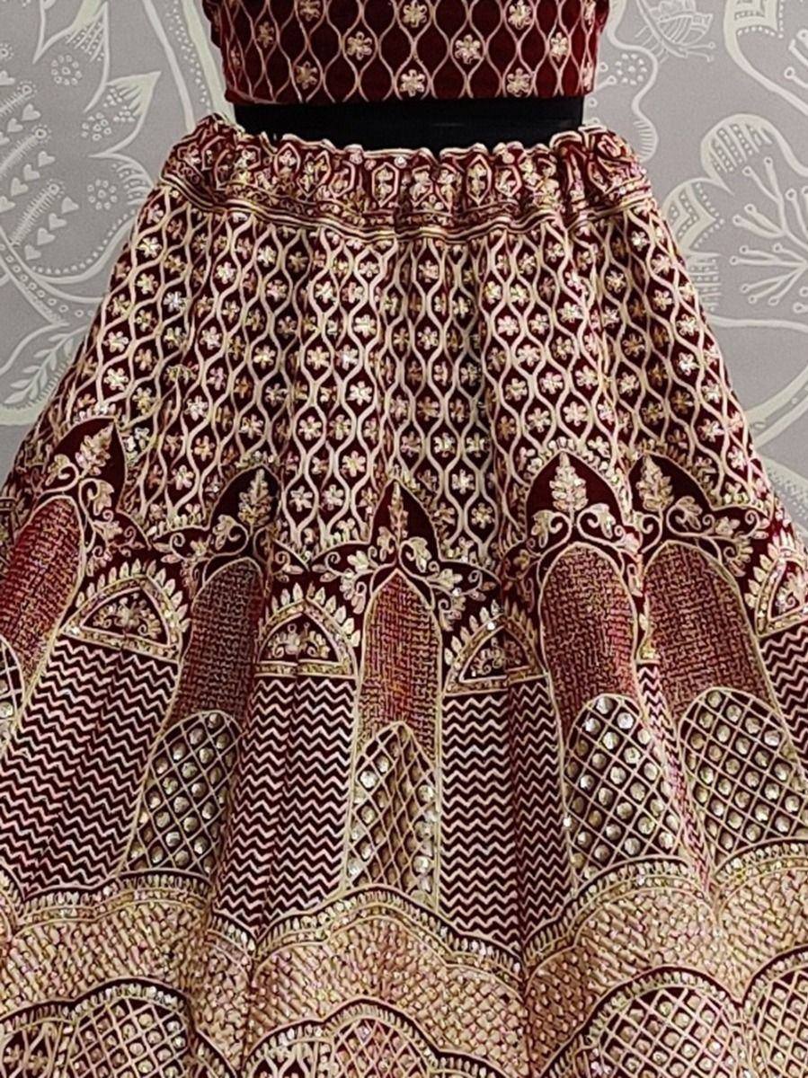 Maroon embroidered lehenga with gold floral and geometric patterns, perfect for Indian ethnic wear