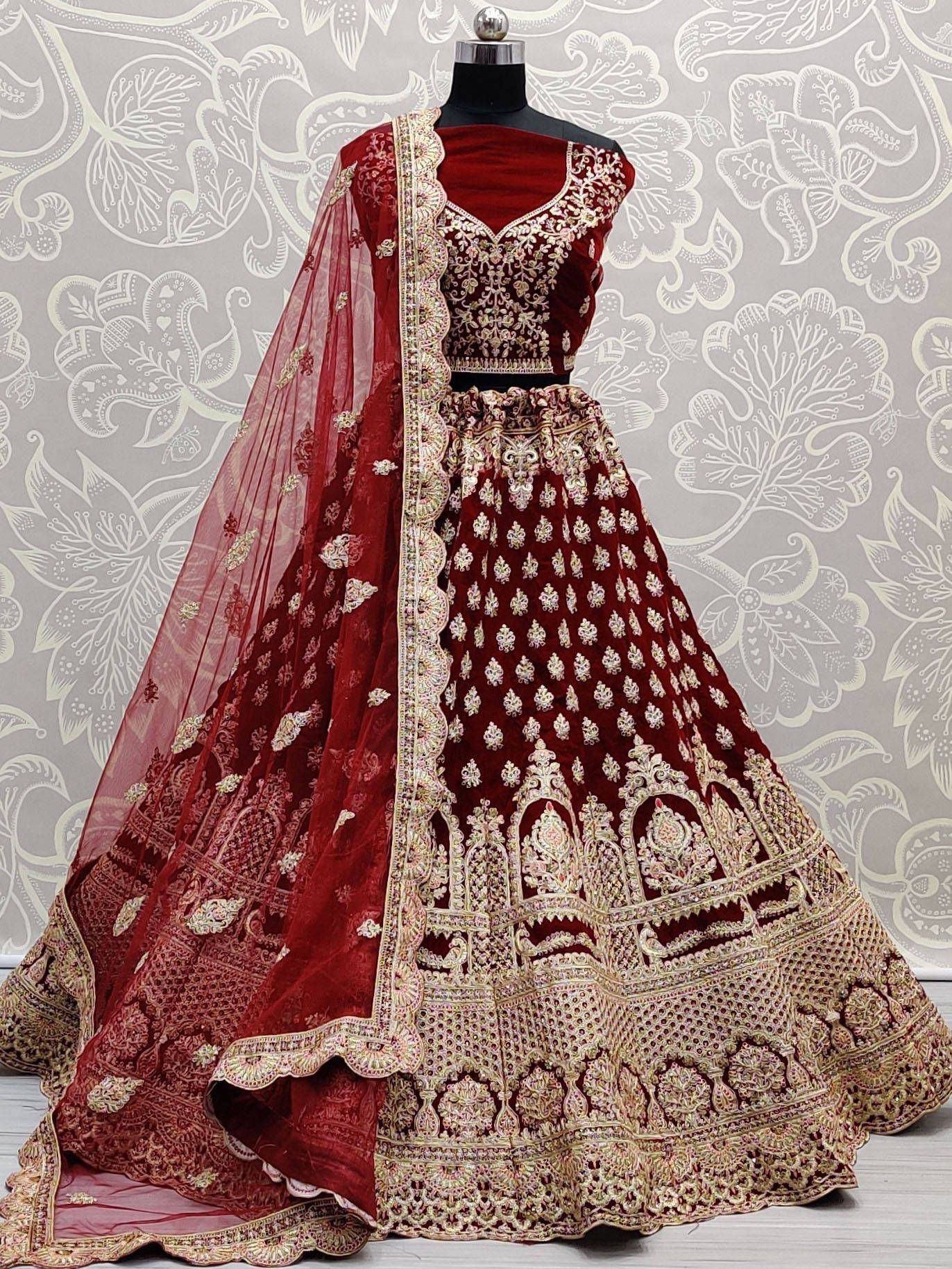 Maroon velvet designer lehenga choli with heavy gold embroidery and matching dupatta, perfect for weddings.