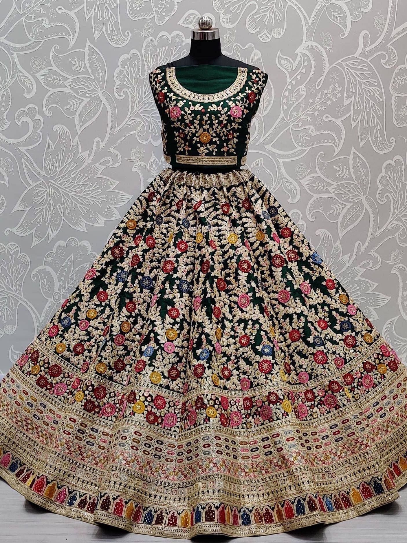 Emerald green designer lehenga choli with heavy floral embroidery and colorful motifs, perfect for weddings and festivals.