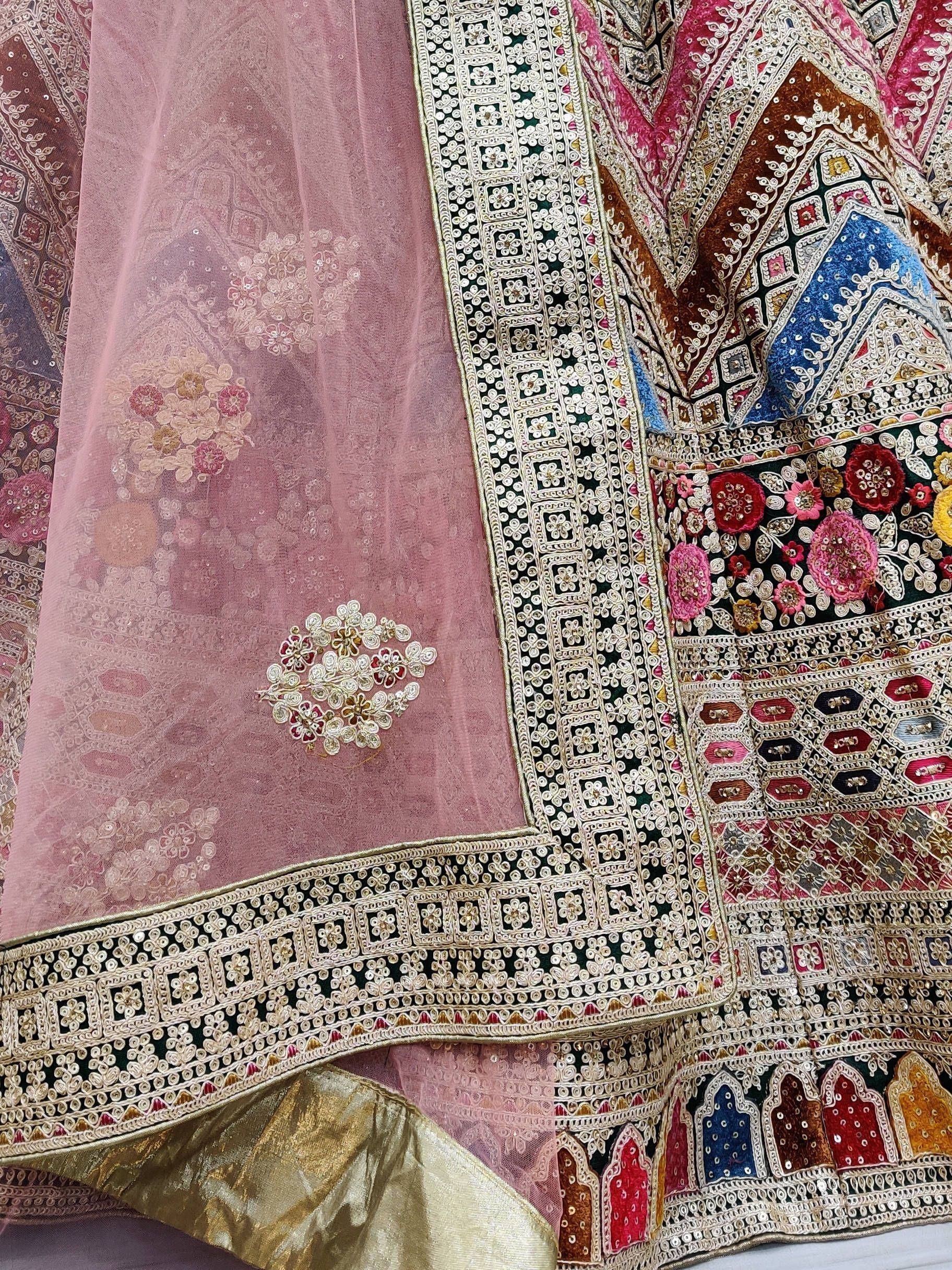 Designer lehenga choli with intricate embroidery, floral motifs, and sequin work in pink, gold, and multicolor.