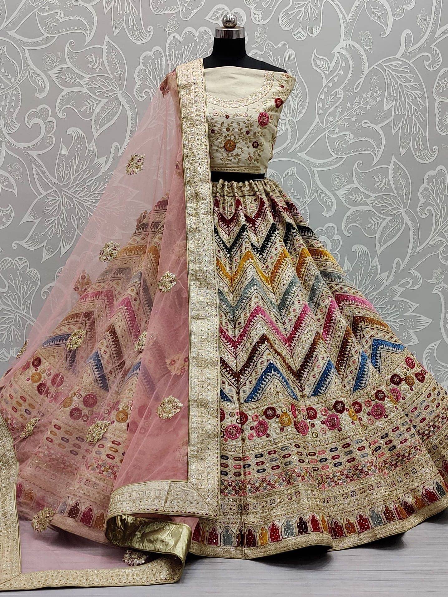 Designer lehenga choli with intricate embroidery, colorful geometric patterns, and pink dupatta for Indian ethnic wear