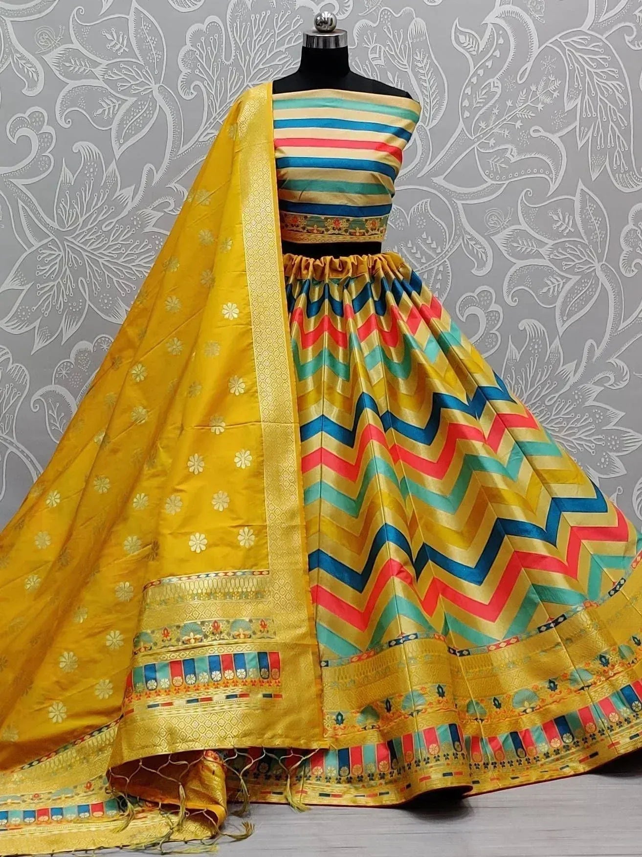 Vibrant yellow lehenga choli with multicolor zigzag print, perfect for Indian ethnic wear occasions.