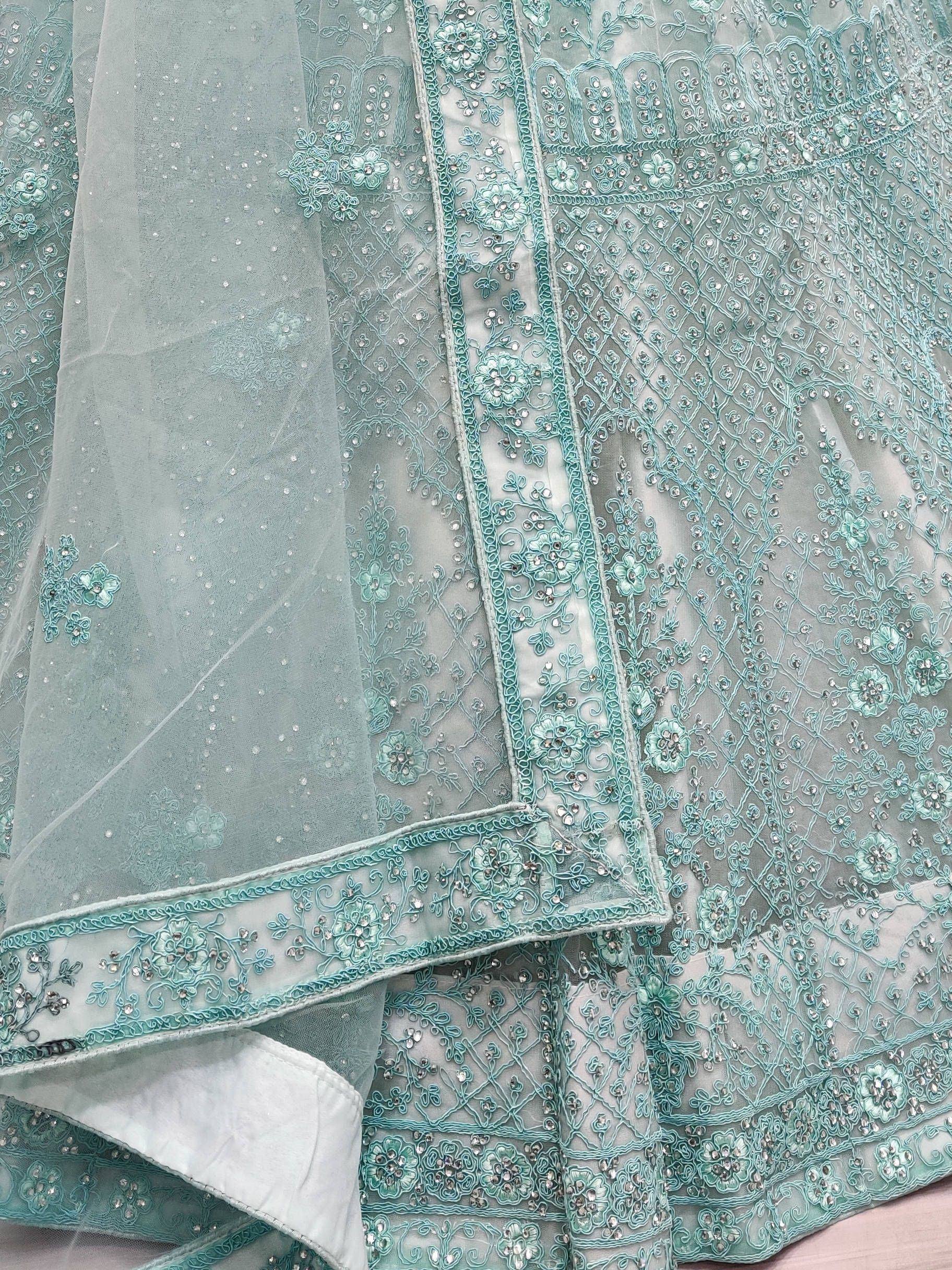 Mint green designer lehenga with intricate floral embroidery and sequin detailing, perfect for Indian ethnic wear.