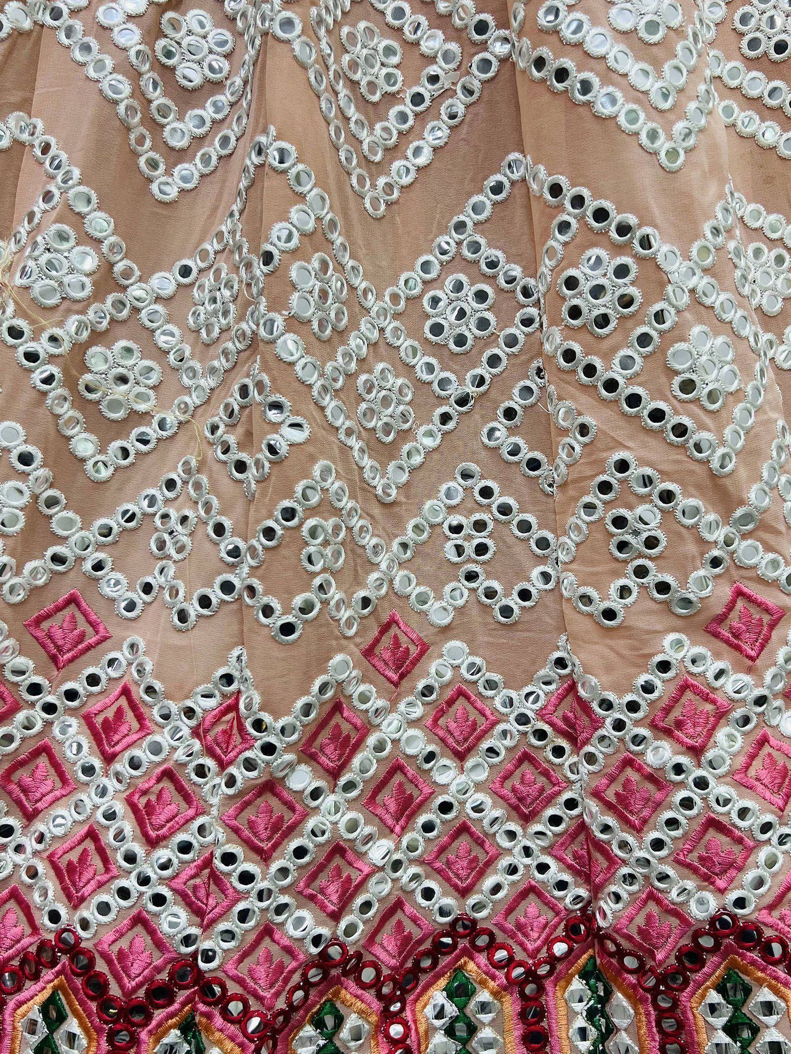 Pink ethnic gown with mirror work and embroidery, featuring geometric patterns and vibrant detailing.
