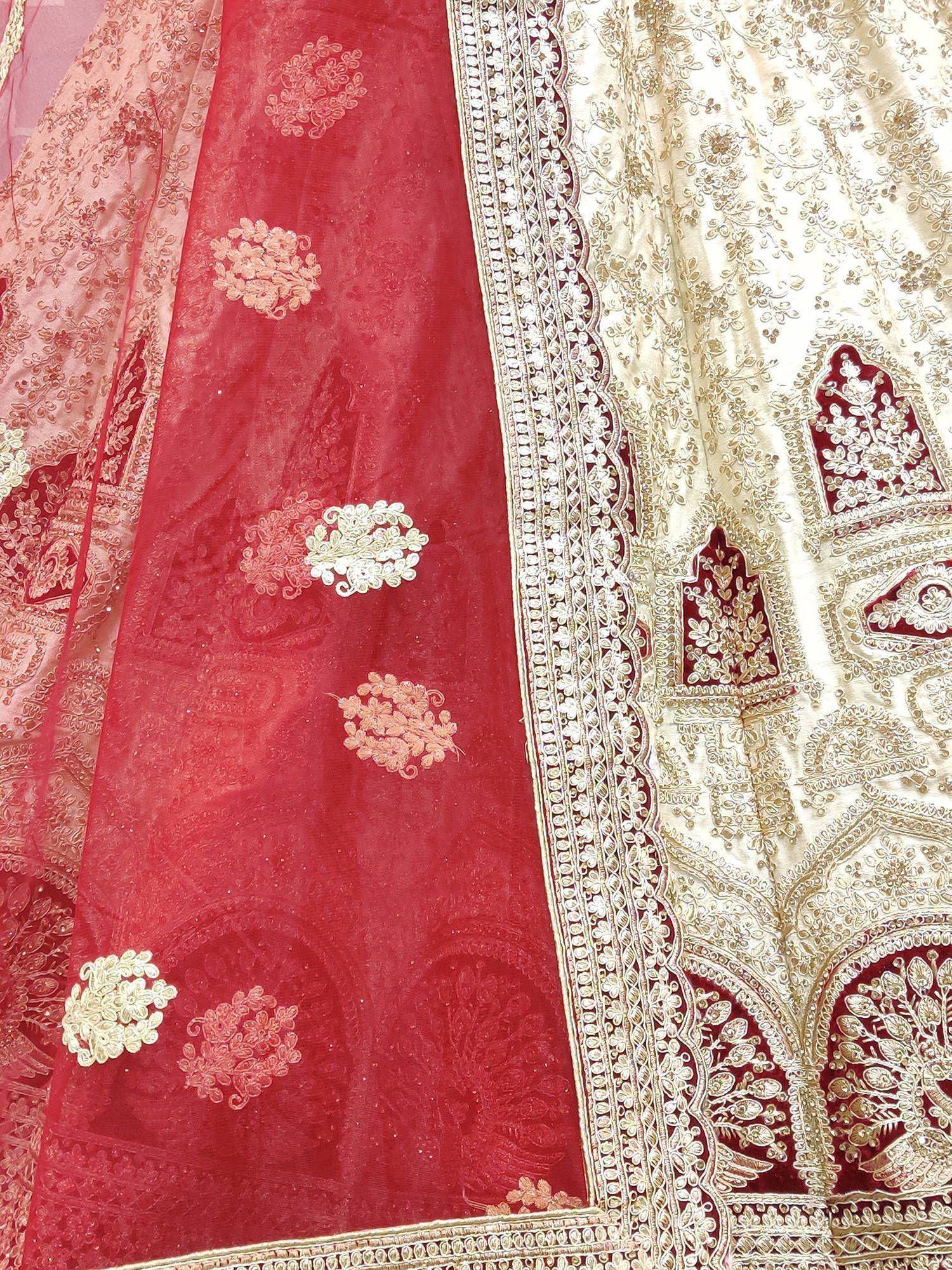 Red and cream embroidered lehenga choli with intricate gold zari work and floral motifs