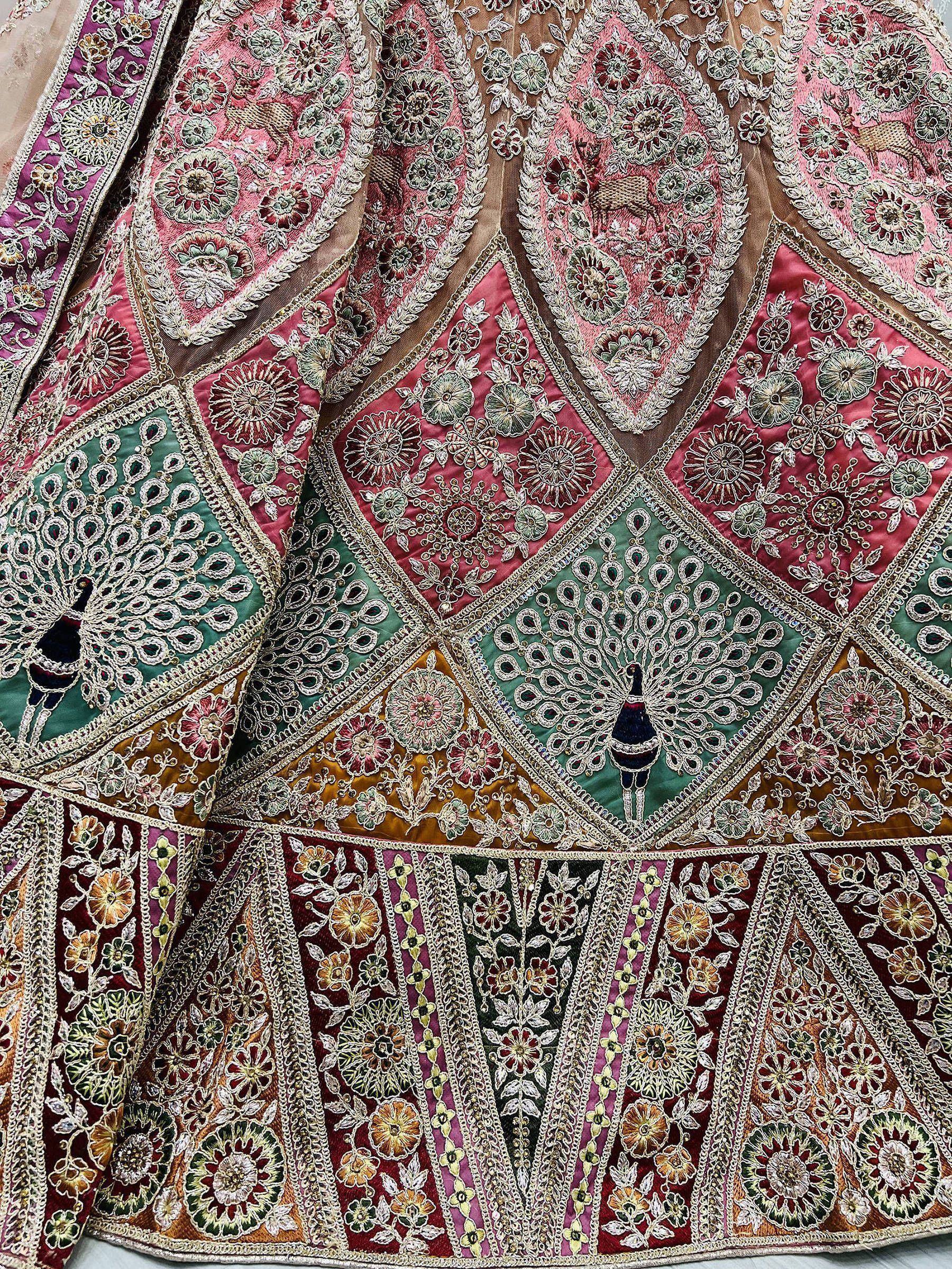 Designer lehenga with peacock embroidery and floral motifs in pink, green, and gold