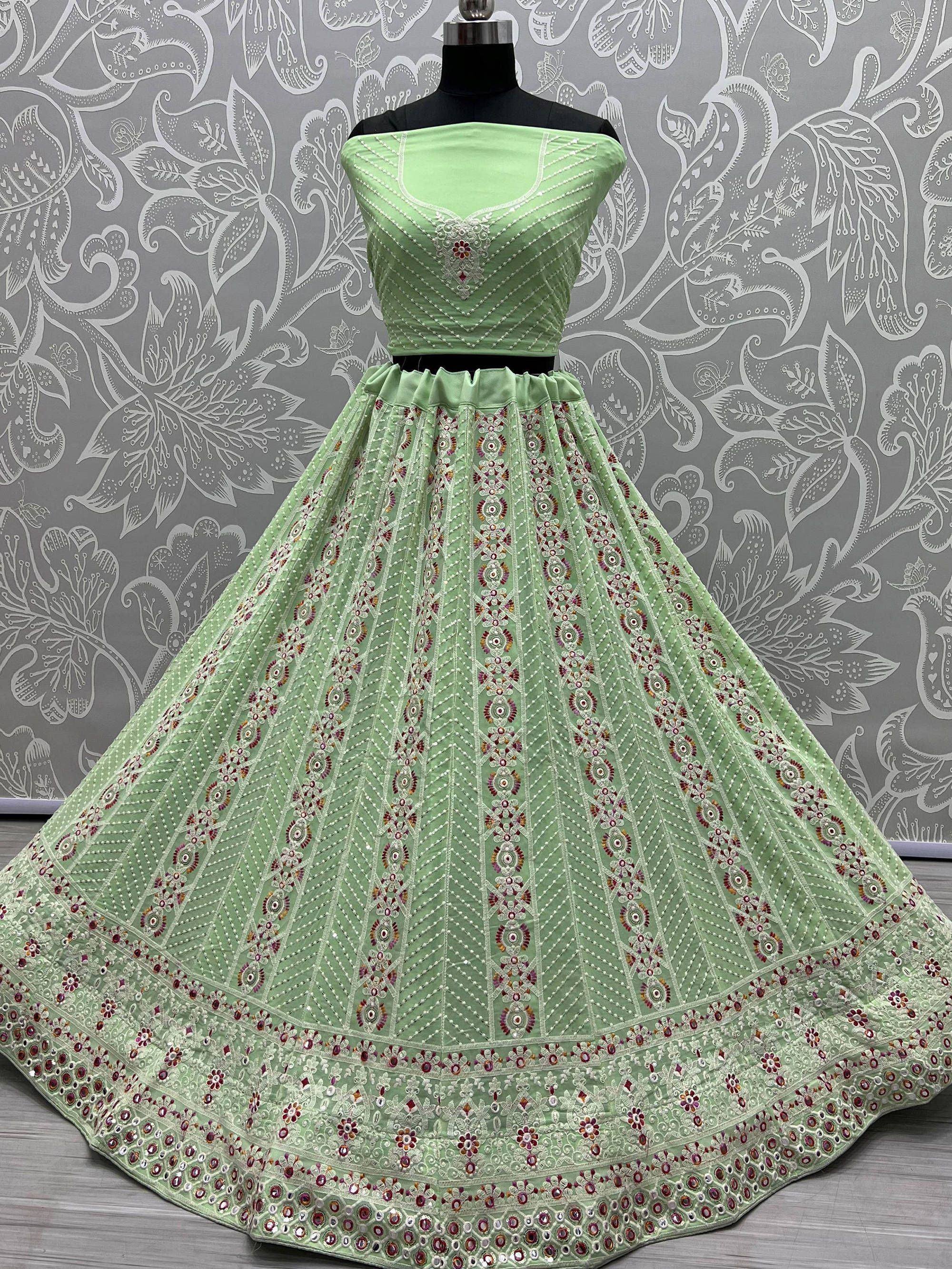 Mint green designer lehenga choli with intricate embroidery and mirror work, perfect for Indian ethnic occasions.