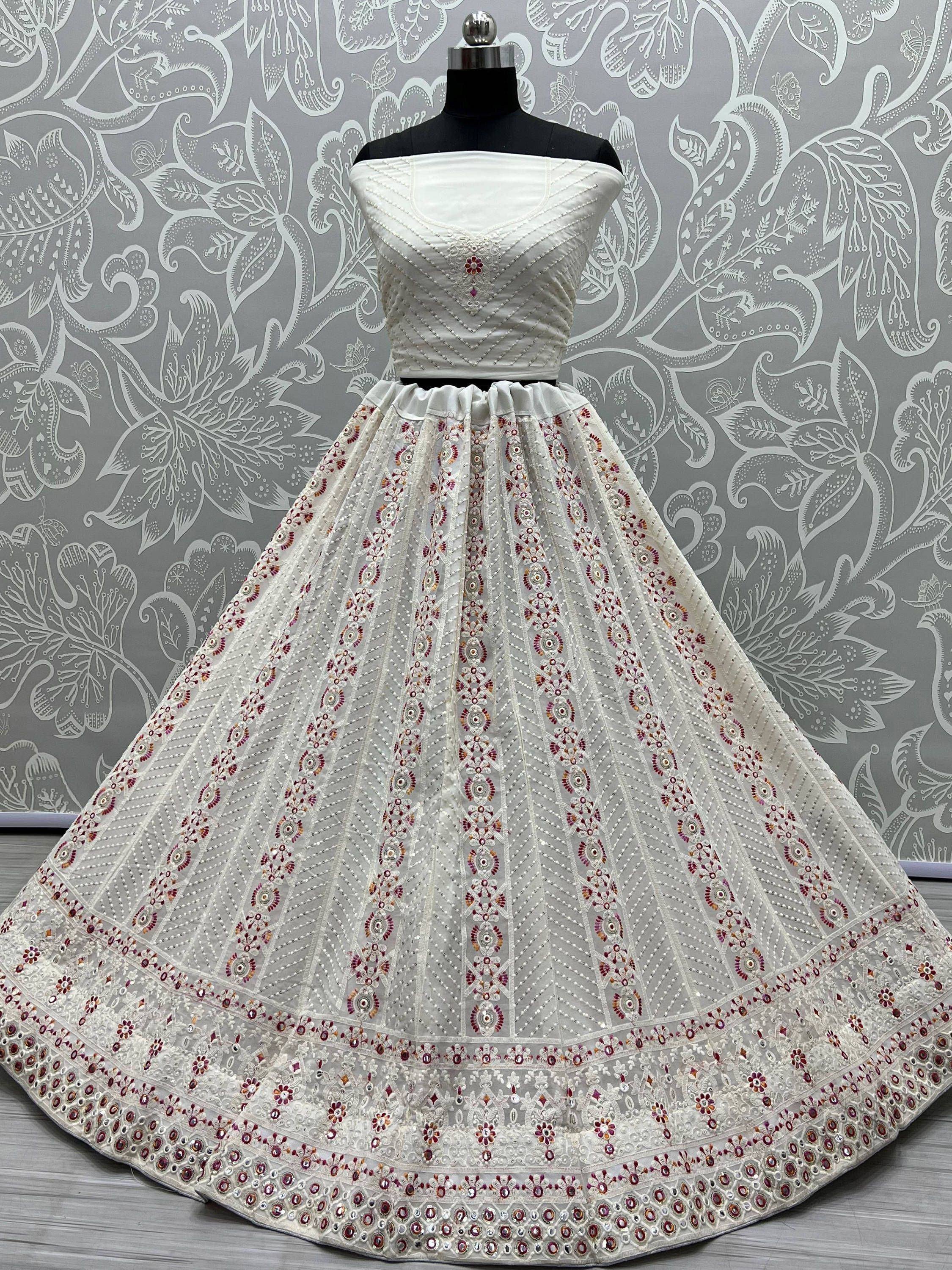 White off-shoulder lehenga choli with intricate red and gold embroidery, perfect for Indian ethnic wear.