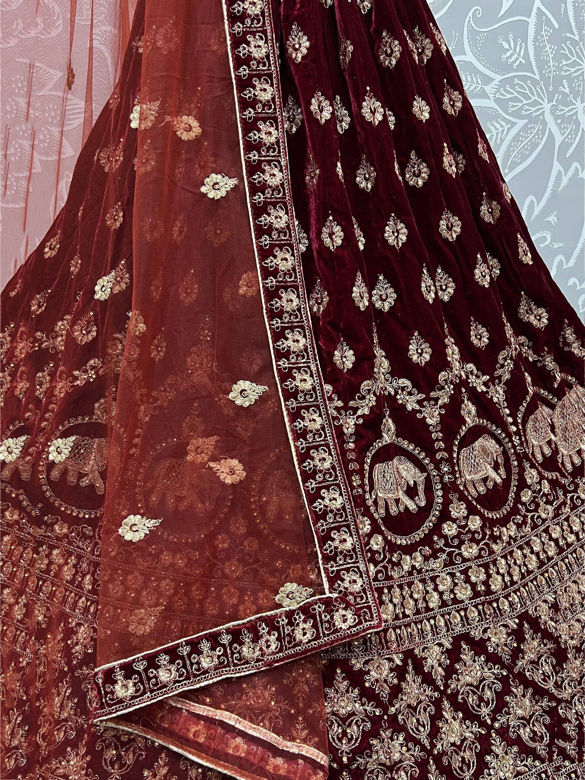 Maroon velvet lehenga choli with gold elephant embroidery and floral zari work, perfect for Indian weddings