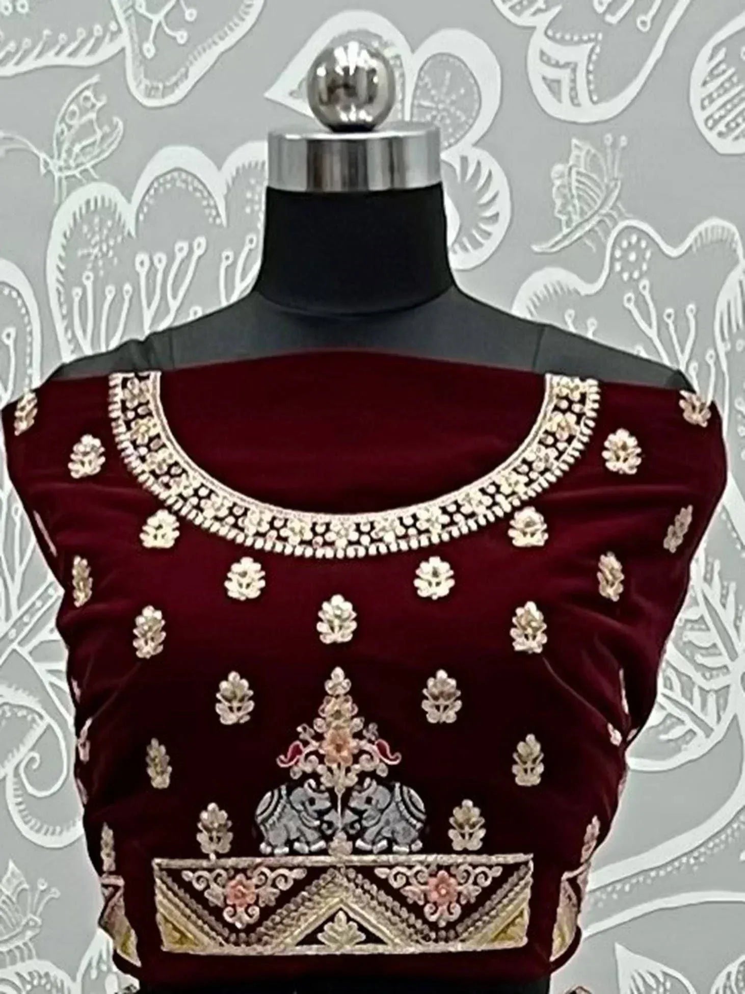 Maroon velvet designer blouse with gold embroidery, floral motifs, and elephant detailing for ethnic wear
