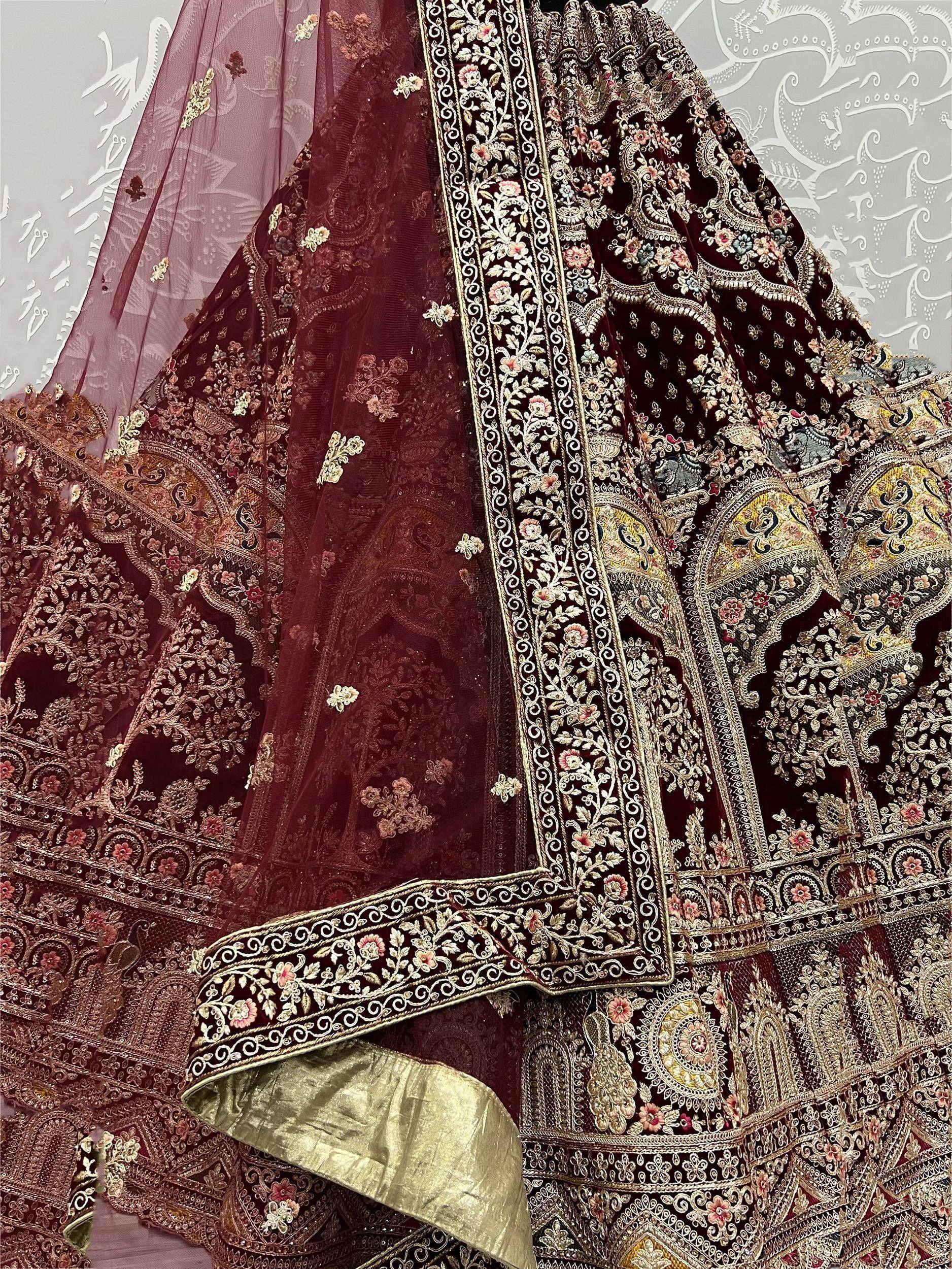 Luxury maroon velvet lehenga choli with intricate gold embroidery and floral motifs, perfect for weddings