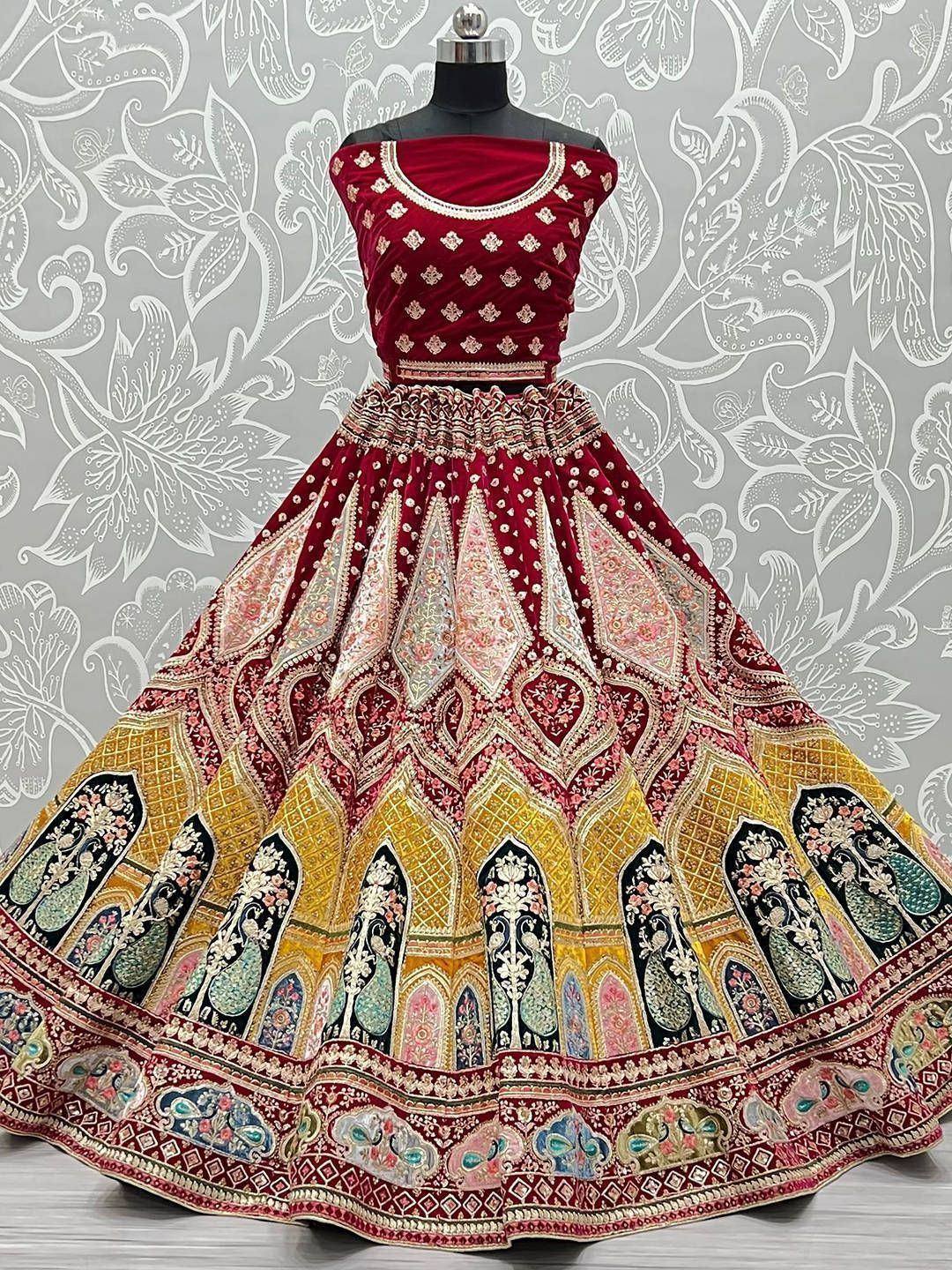 Red velvet designer lehenga choli with intricate embroidery and peacock motifs, perfect for Indian weddings
