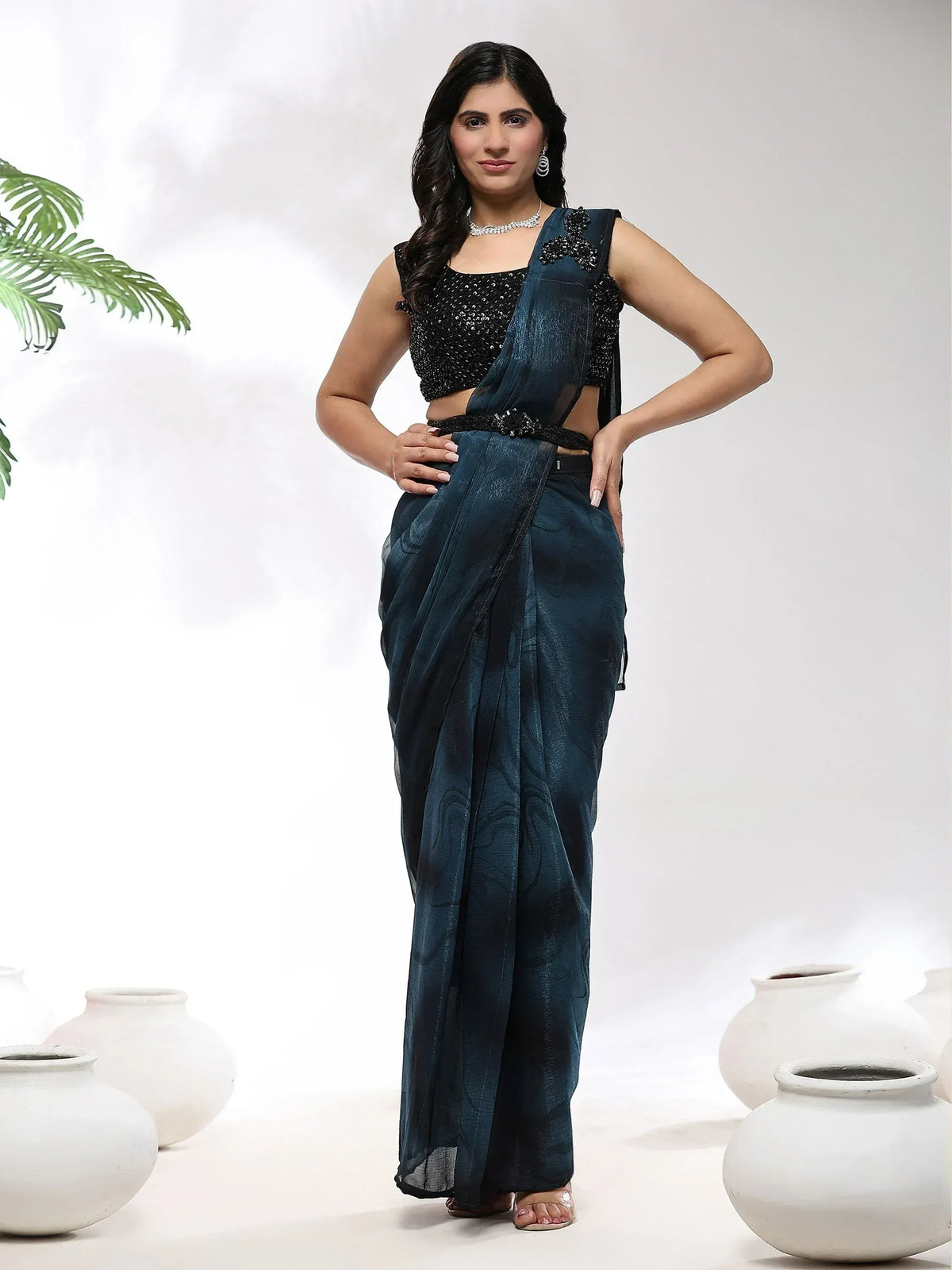 Woman in elegant dark teal saree with black sequin blouse, perfect for Indian ethnic occasions