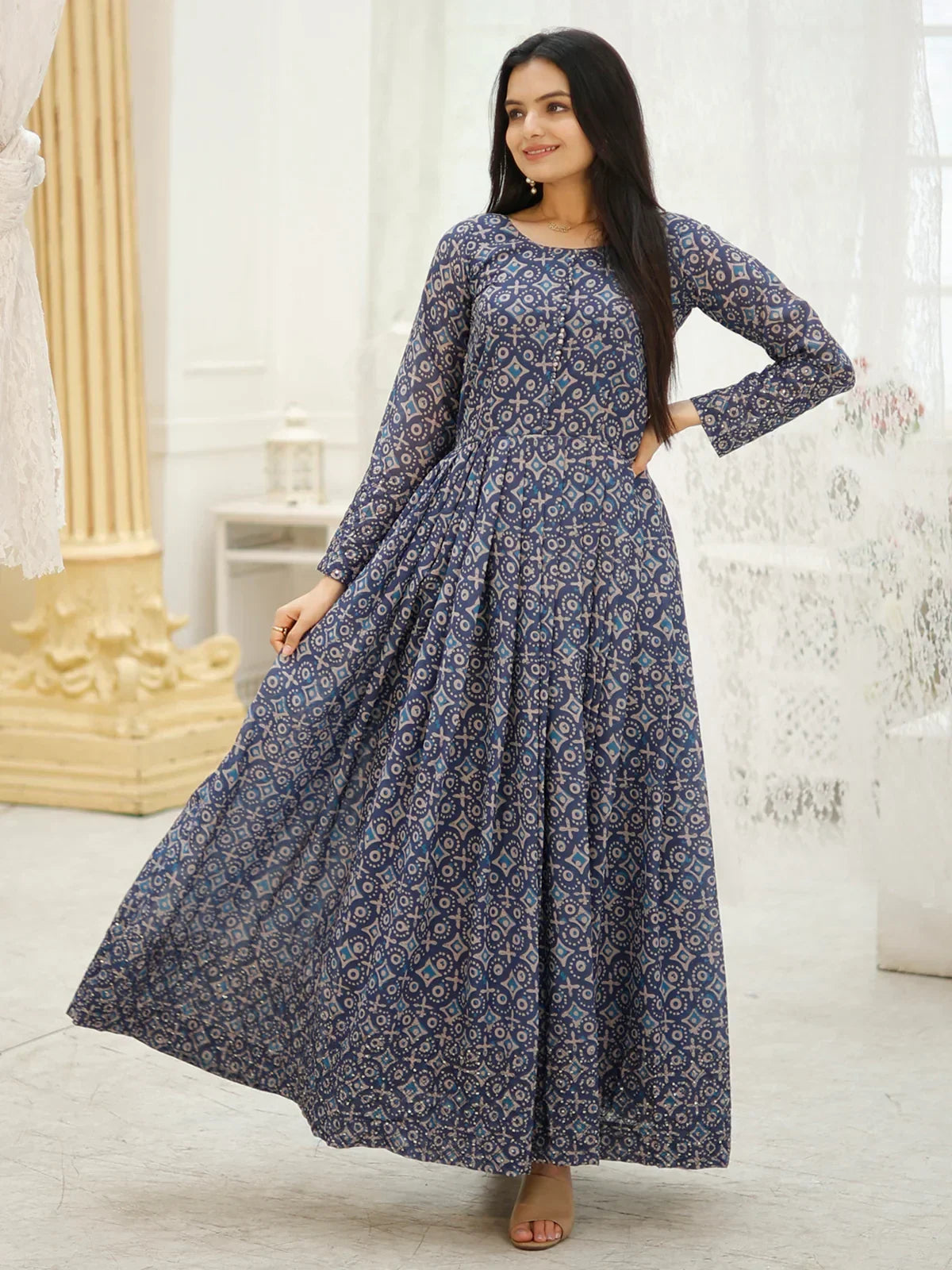 Woman in a blue printed Anarkali dress with long sleeves and geometric ethnic patterns