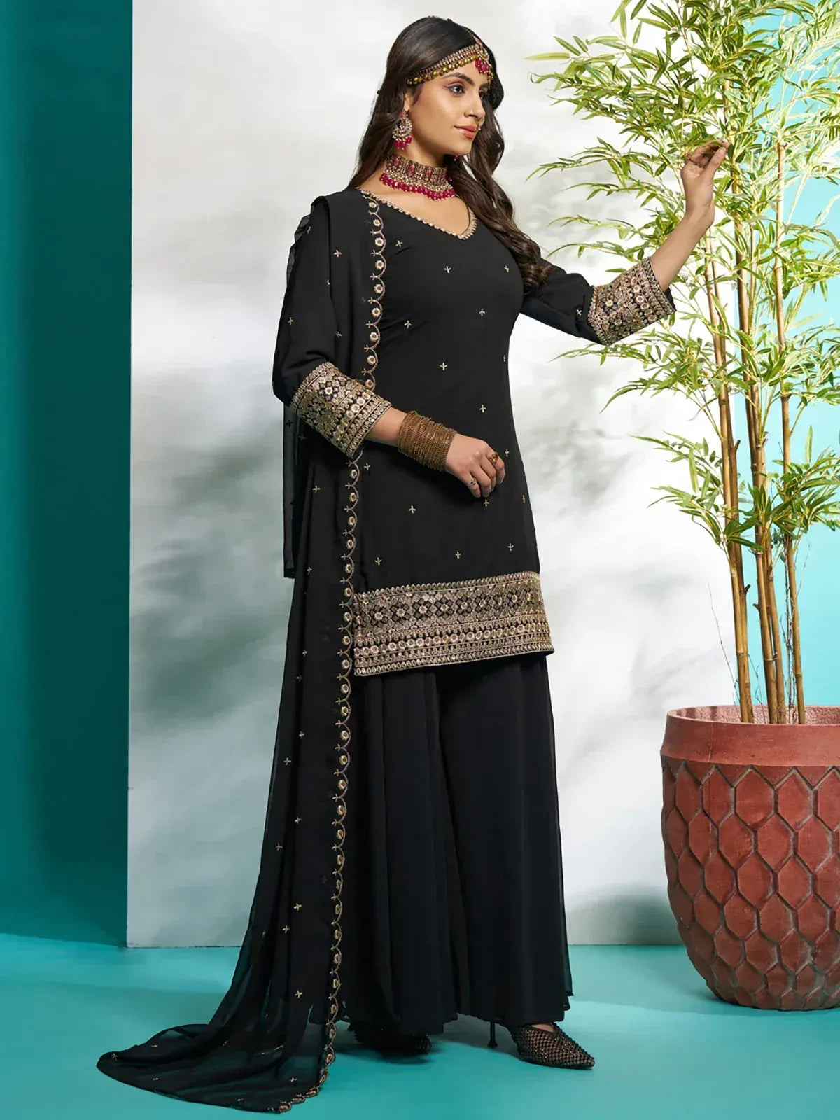 Black embroidered salwar kameez with gold detailing, perfect for ethnic occasions and festive wear.