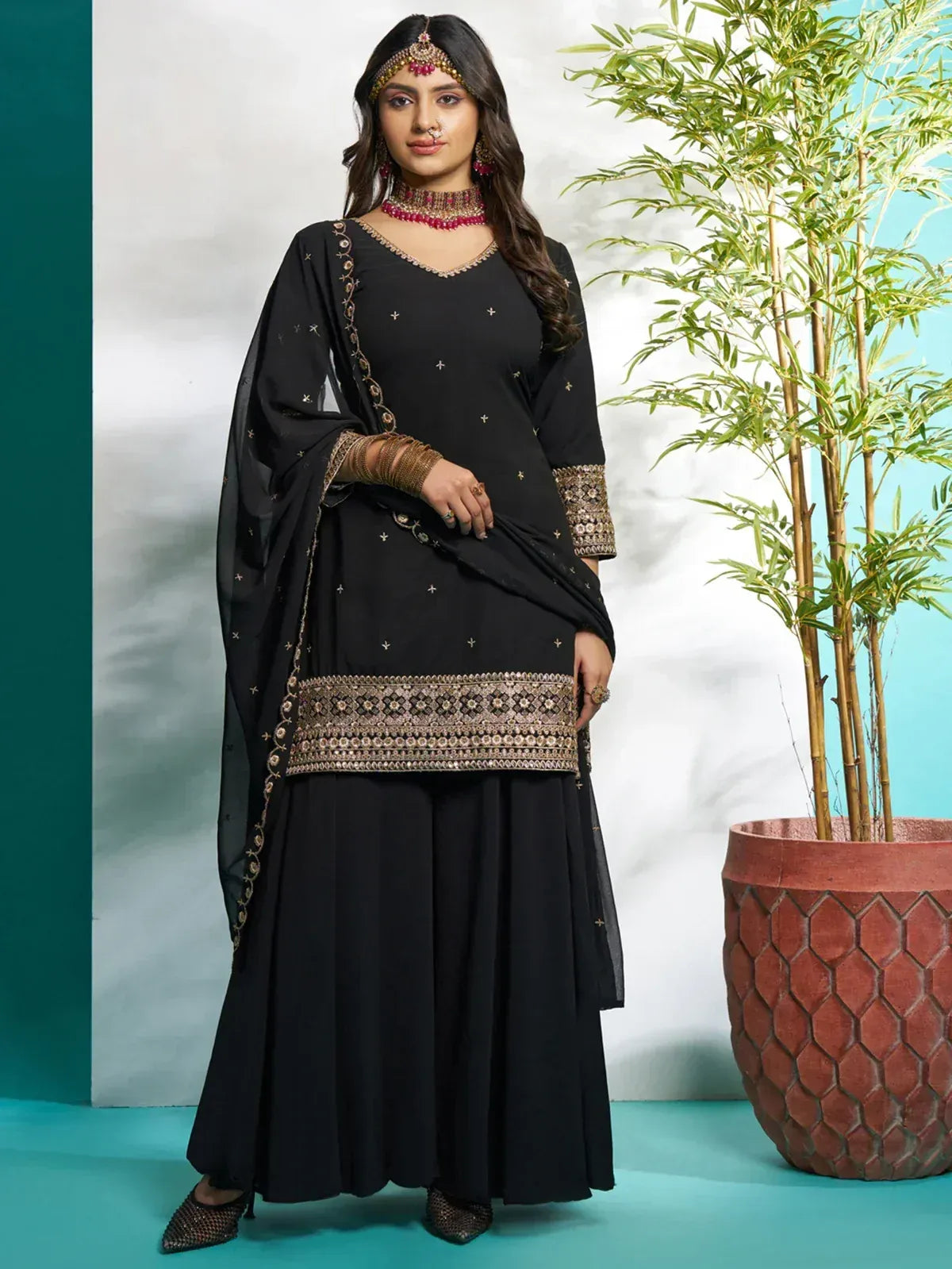 Black embroidered salwar kameez with gold detailing, perfect for ethnic occasions and festive wear.