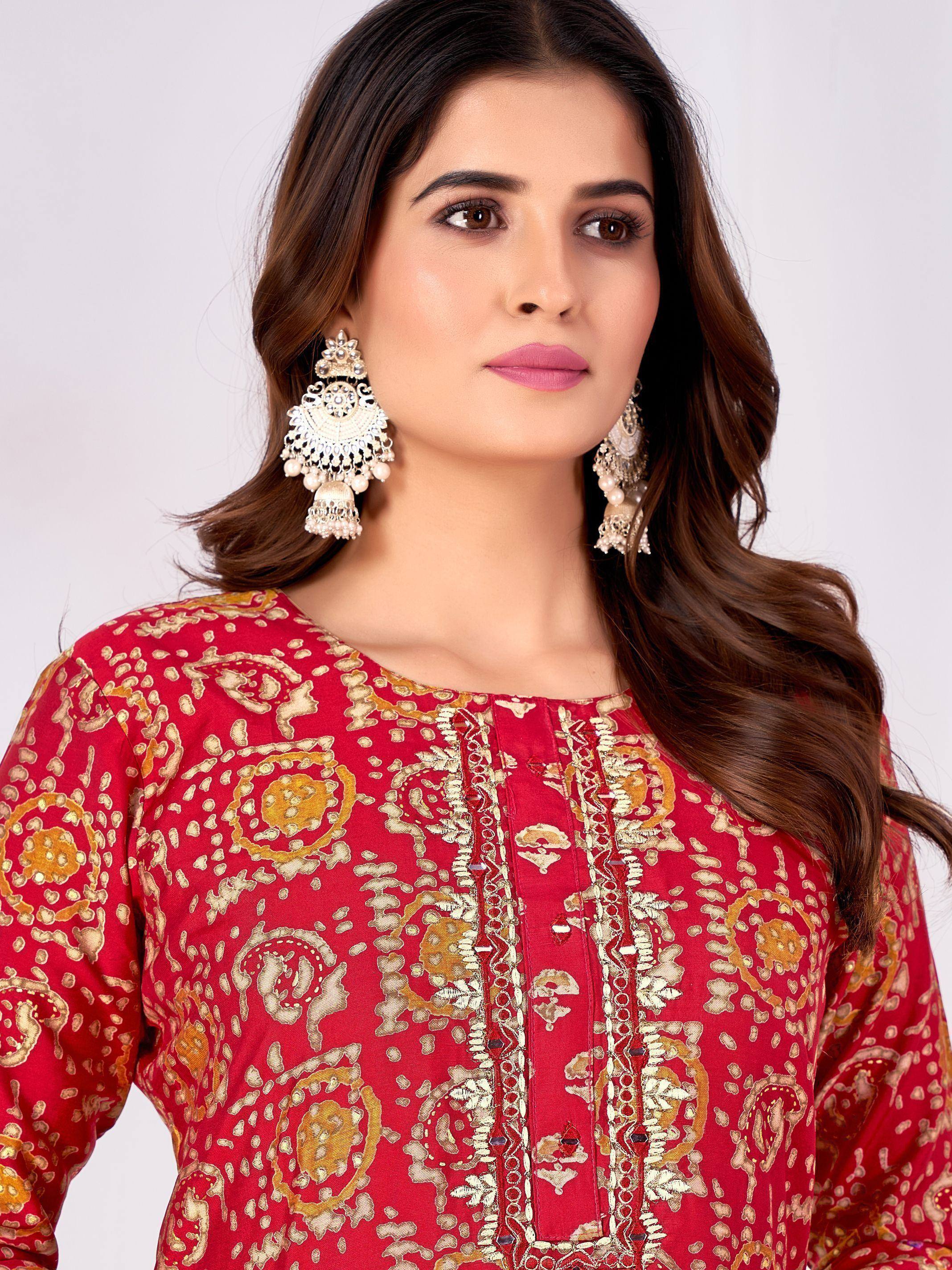 Red ethnic kurti with gold paisley print and embellished neckline, paired with ornate jhumka earrings